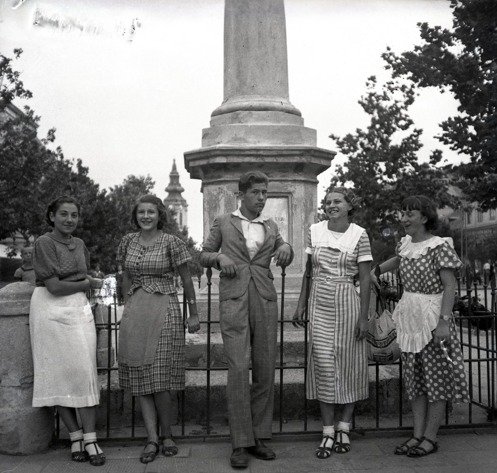 Hungary, Jászberény, Lehel vezér (Apponyi) tér, előtérben az 1848-49-es emlékmű (Gerenday Antal, 1870.), háttérben a Nagyboldogasszony-templom., 1937, Morvay Kinga, tableau, youth, Fortepan #140584