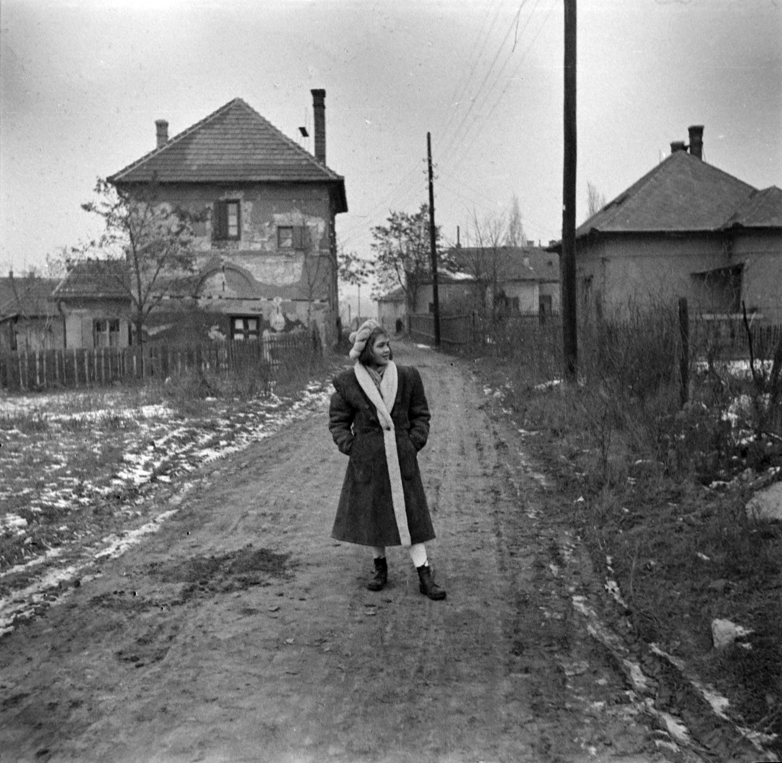 1952, Miklós Lajos, hands in pockets, street view, photo aspect ratio: square, lady, dirt road, winter coat, cap, boots, Fortepan #140674