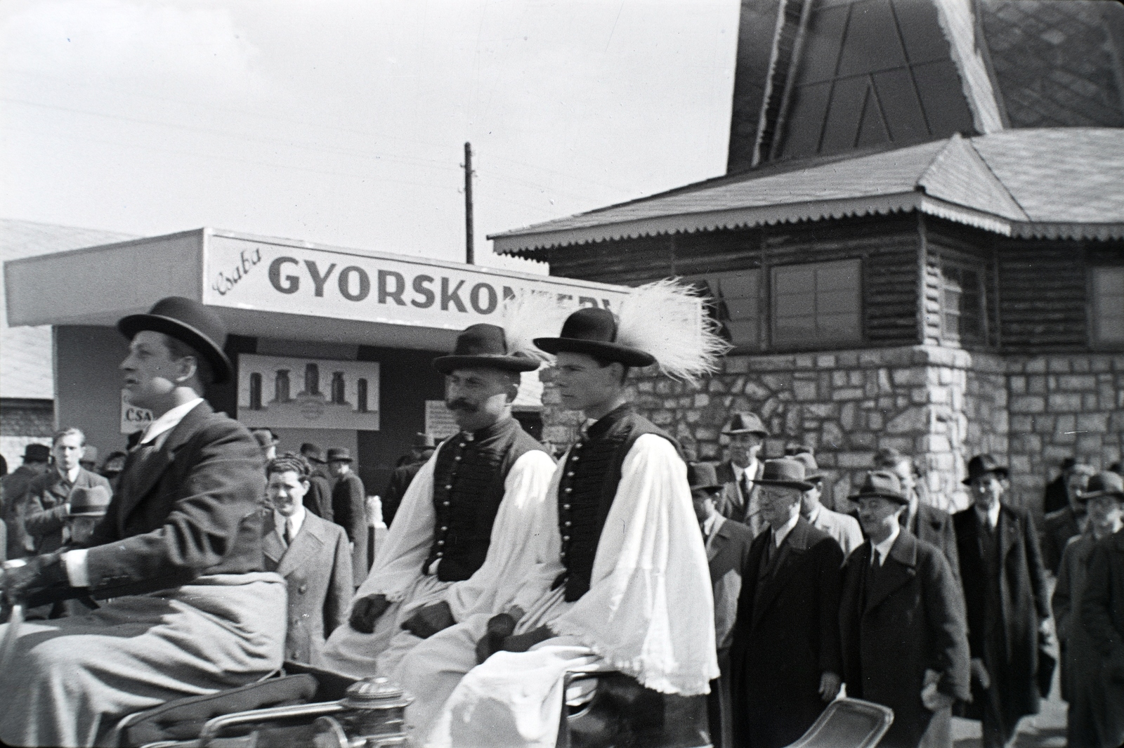 Hungary, Budapest X., Albertirsai út, Mezőgazdasági kiállítás. A felvétel Csabai Gyorskonzer reklámja és a Futura, a Magyar Szövetkezeti Központok Áruforgalmi Részvénytársaságának pavilonja előtt készült., 1943, Miklós Lajos, folk costume, teamster, maidenhair, pants, Budapest, Fortepan #140870