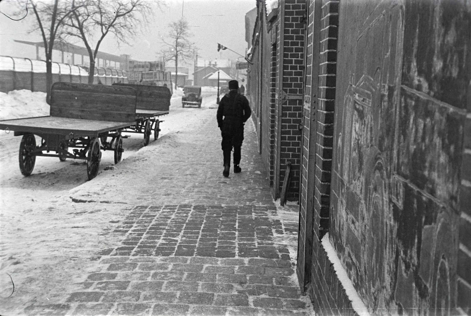 Hungary, Budapest X., Vaspálya utca 4., Miklós Lajos járműgyártó mester üzeme előtt álló platós lovaskocsik. Balra a háttérben a Kőbánya alsó vasútállomás látszik., 1944, Miklós Lajos, Budapest, Horse-drawn carriage, snow, train station, pavement, Fortepan #141037