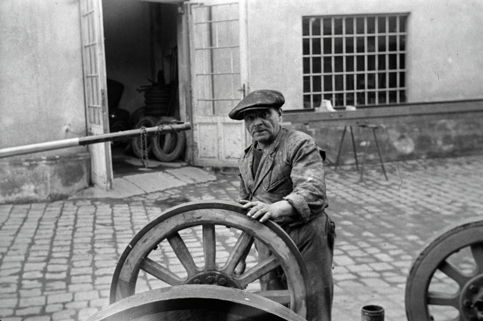 Magyarország, Budapest X., Vaspálya utca 4., a felvétel Miklós Lajos járműgyártó mester üzemének udvarában készült., 1944, Miklós Lajos, Budapest, munkás, állvány, micisapka, gumiabroncs, belső udvar, üzem, kerék, Fortepan #141143