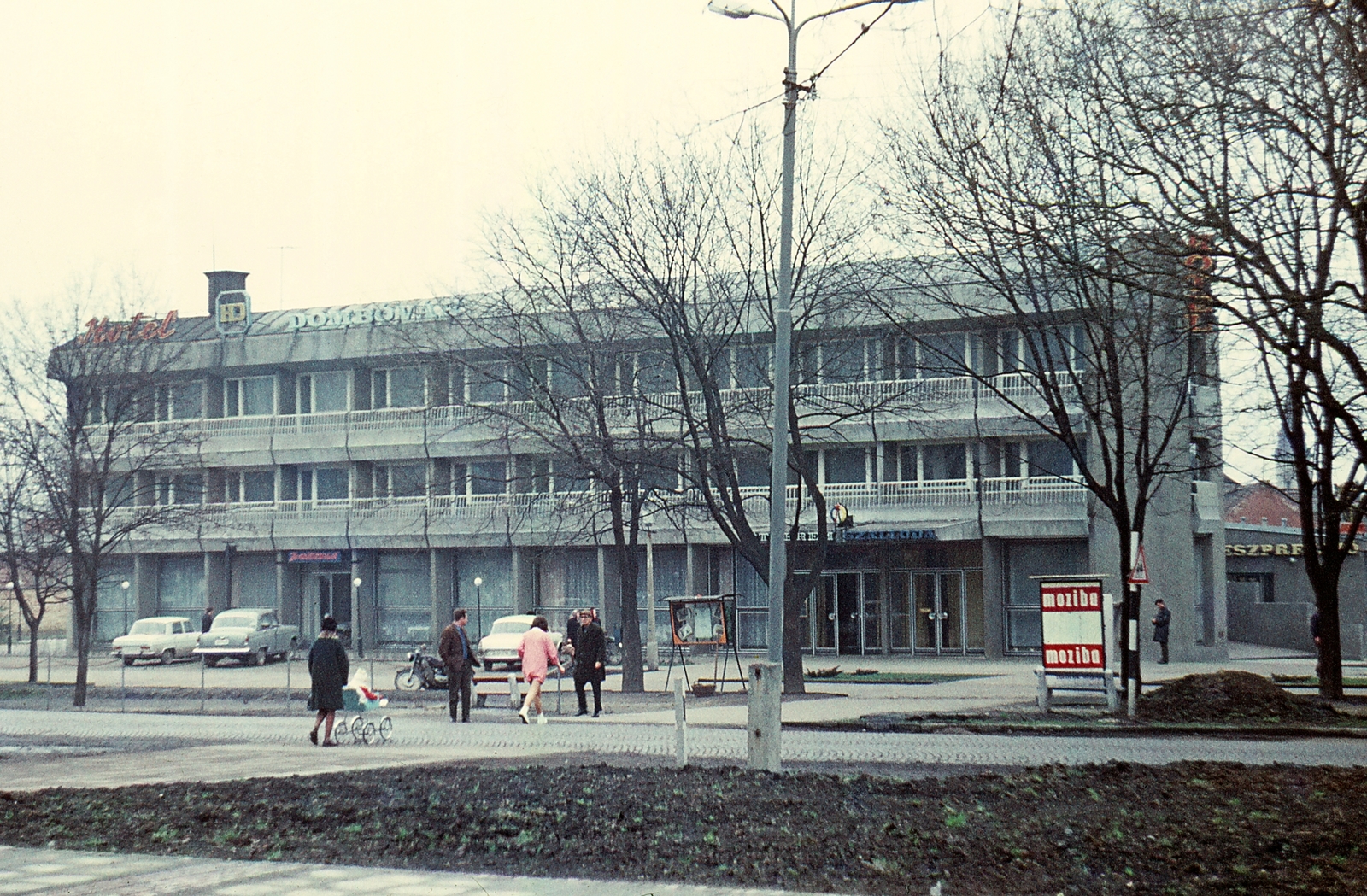 Hungary, Dombóvár, Hunyadi tér, Hotel Dombóvár., 1972, Erky-Nagy Tibor, colorful, baby carriage, hotel, Skoda-brand, neon sign, M21 Wolga, movie schedule, Fortepan #14126