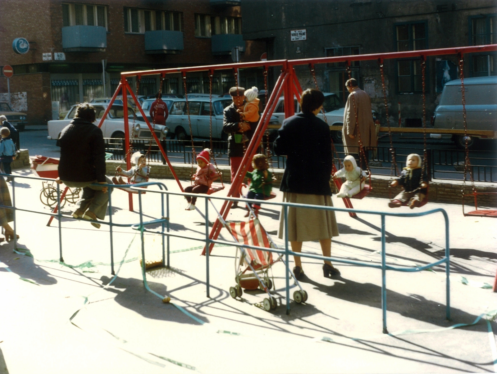 Magyarország, Budapest V., Bástya utcai játszótér, háttérben a Veres Pálné utca - Só utca sarkán álló házak., 1985, Hlatky Katalin-Főkert, játszótér, színes, hinta, babakocsi, korlát, Budapest, korláton ülni, Fortepan #141294