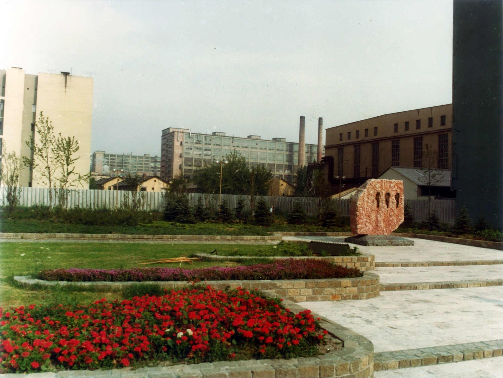 Hungary, Budapest II., Margit körút (Mártírok útja), a Mártírok emlékműve (Kiss Nagy András, 1979.) az Ipari Minisztérium épülete mellett. Háttérben a mai Millenáris helyén a Ganz Villamossági Művek épületei., 1980, Hlatky Katalin-Főkert, Budapest, flower bed, Fortepan #141356