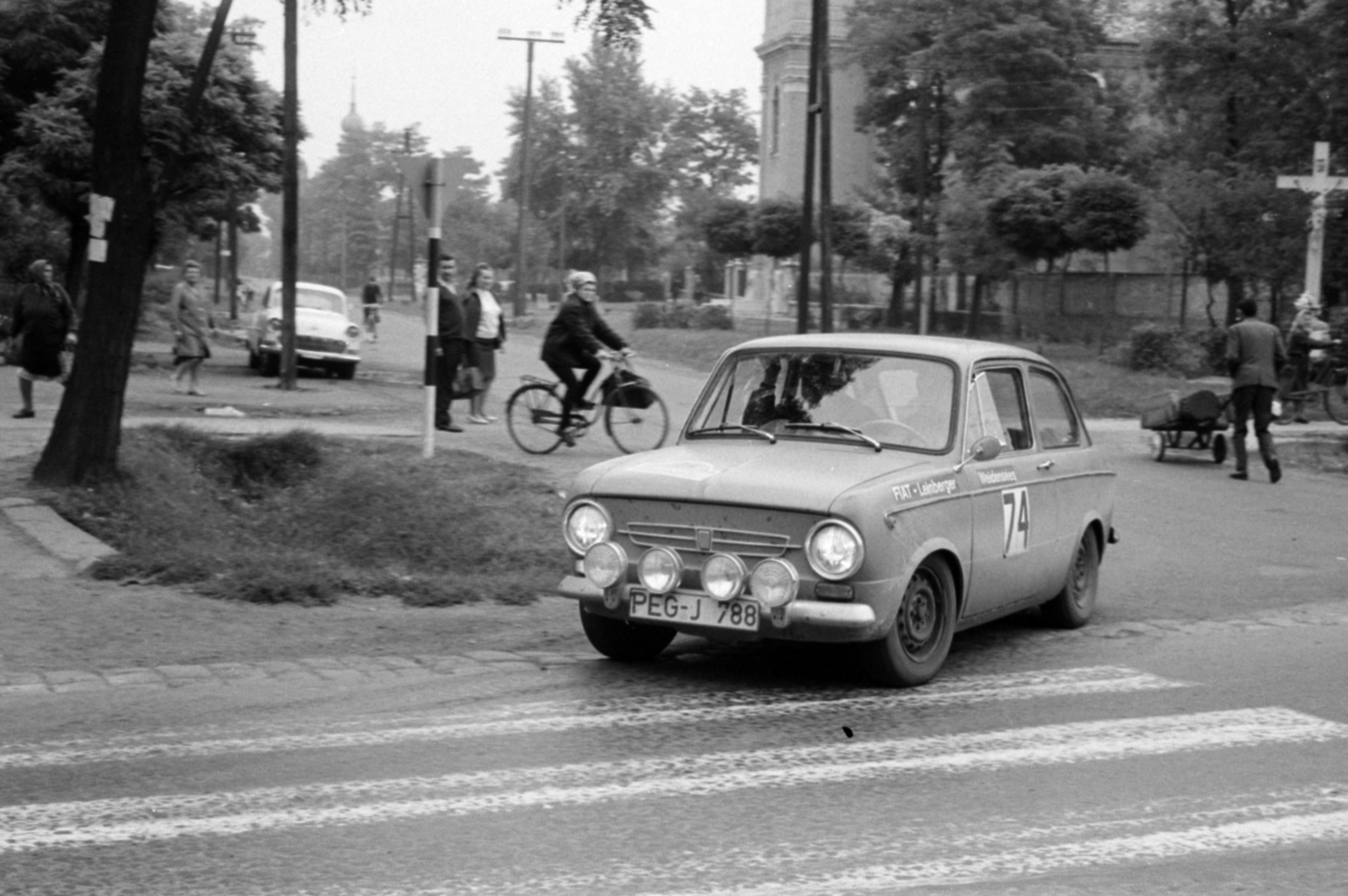 Magyarország, Üllő, Pesti út, szemben a Templom tér, jobbra a Keresztelő Szent János-templom. München - Bécs - Budapest nemzetközi autós rallye., 1969, Péterffy István, Fiat-márka, olasz gyártmány, autóverseny, Fiat 850, kerékpár, gyalogátkelő, Fortepan #141796