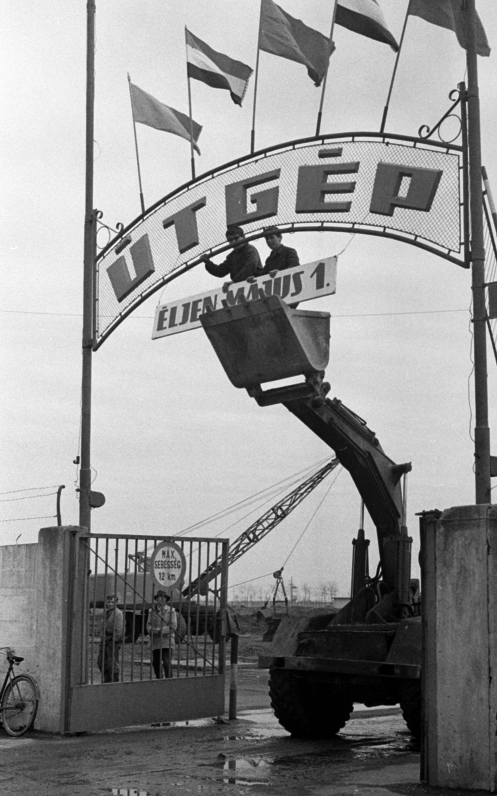 Hungary, Cegléd, a felirat még ÚTGÉP, de ekkor már KÖZGÉP Vállalat főkapujának május 1-i feldíszítése., 1971, Péterffy István, label, flag, hoist, gate, Fortepan #142390