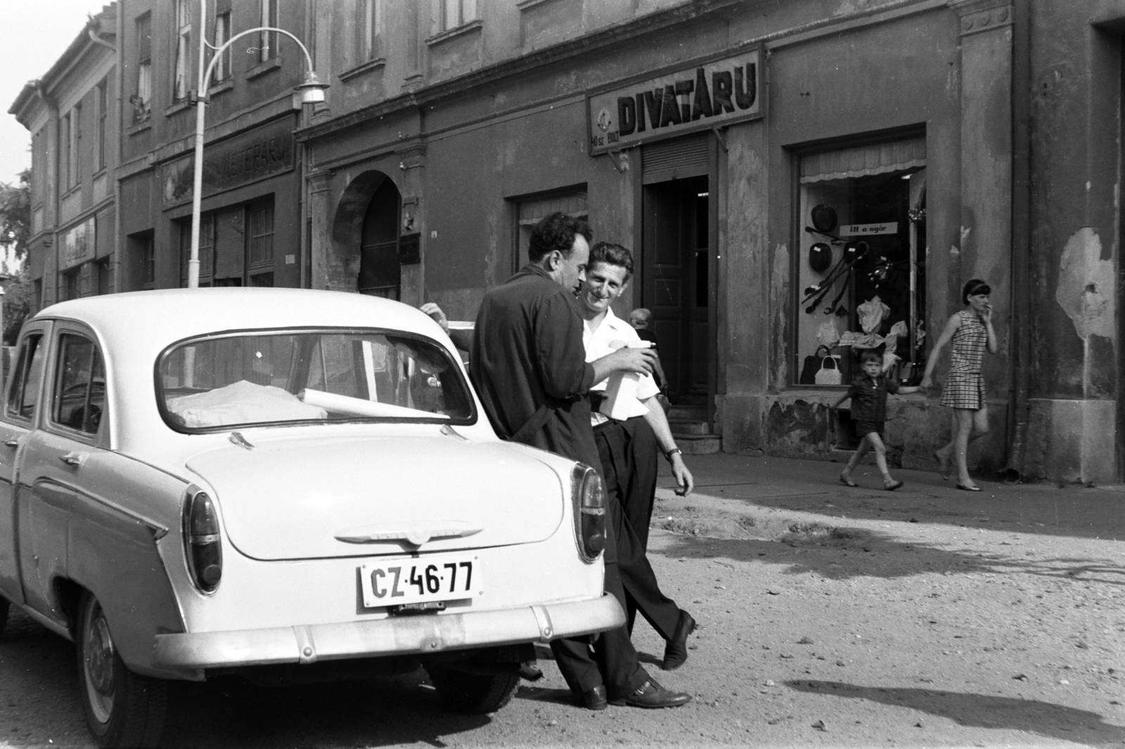 Hungary, Kapuvár, Fő tér., 1966, Chuckyeager tumblr, Show window, sign-board, street view, genre painting, Moskvitch-brand, number plate, Fashion store, Fortepan #143285