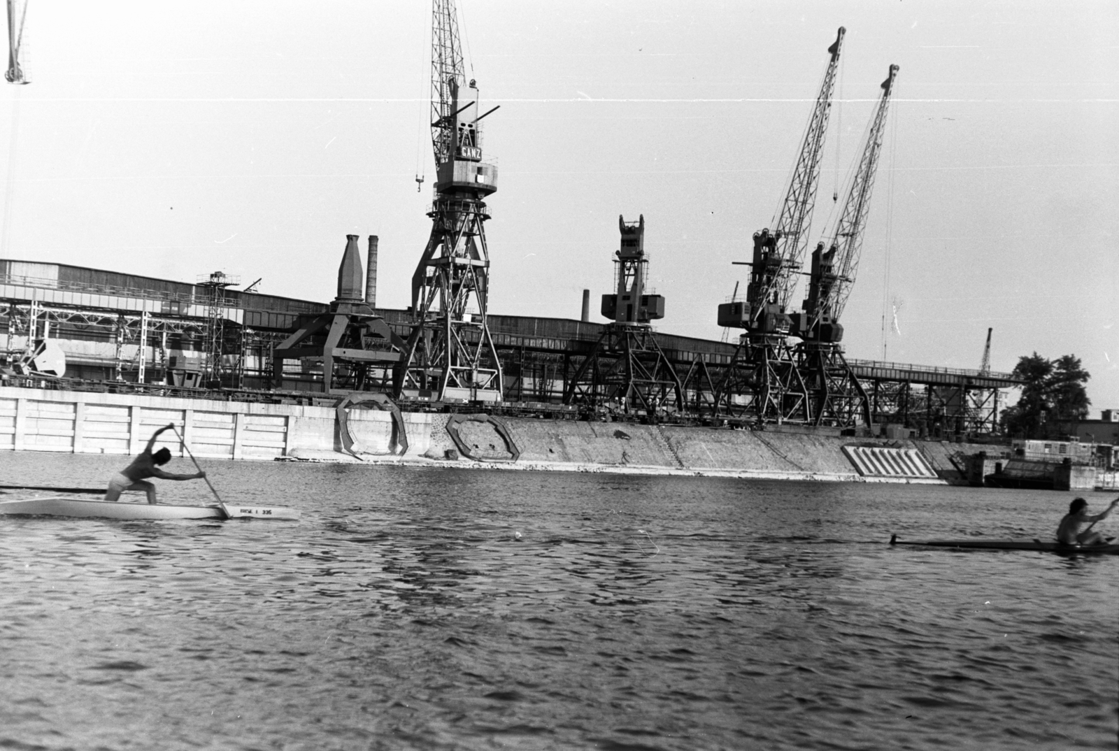 Hungary, Budapest XIII., Újpesti-öböl a Népsziget felől nézve, a KSI (Központi Sportiskola) kajakosa és kenusa edzésen. Túlparton a Magyar Hajó- és Darugyár Angyalföldi Gyáregysége., 1970, Chuckyeager tumblr, kayak, canoe, Budapest, gantry crane, Fortepan #143357