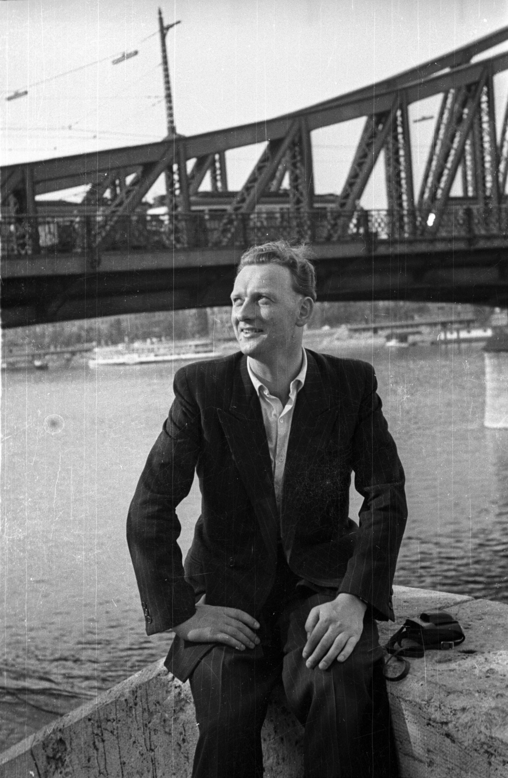 Hungary, Budapest XI., Műegyetem rakpart, háttérben a Szabadság híd., 1955, Szent-tamási Mihály, portrait, bridge, camera, man, shore, Danube, sitting, Budapest, Duna-bridge, János Feketeházy-design, Fortepan #14359