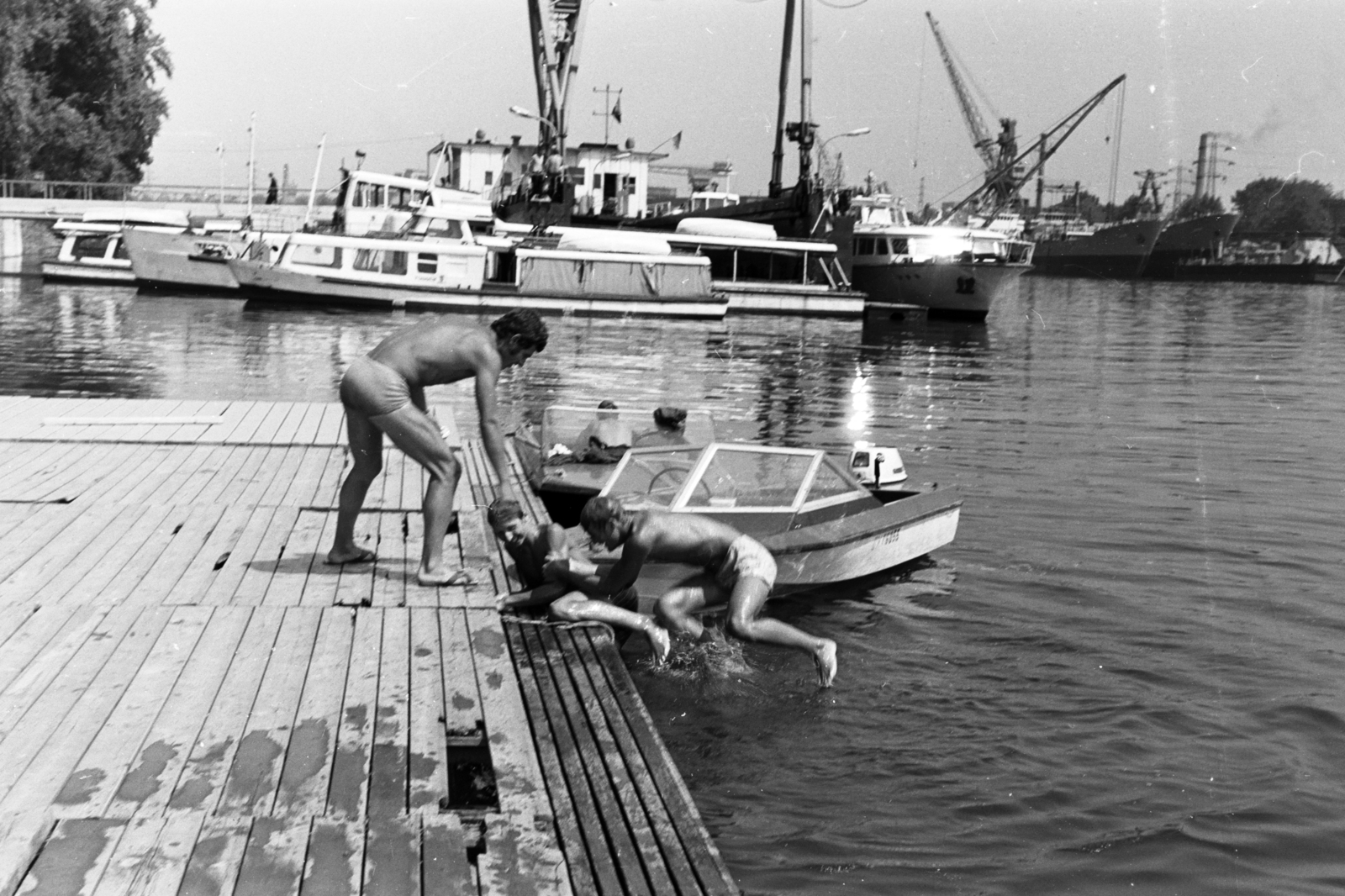 Magyarország, Budapest XIII., Újpesti-öböl, a felvétel a KSI (Központi Sportiskola) vízitelepének stégjén, a Népszigetnél készült. A Tündér motoros személyhajó takarásában egy úszódokk., 1972, Chuckyeager tumblr, stég, motorcsónak, Tünde hajó, Budapest, úszódokk, motoros személyhajó, Fortepan #143657