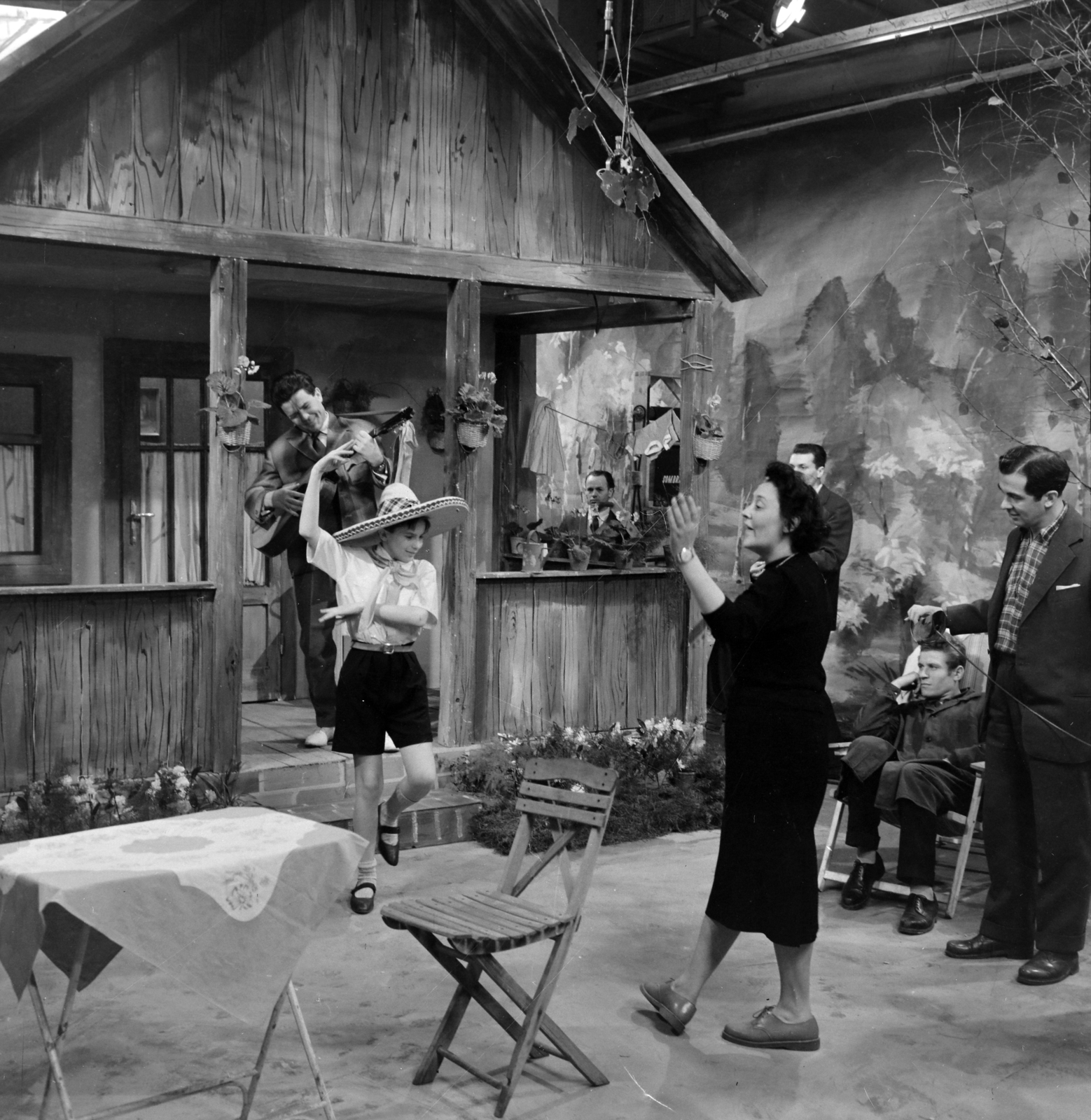 Magyarország, Budapest V., az MTV stúdiója Mihalkov Sombrero című művéből készült ifjúsági tévéjáték felvételekor. Kende Márta rendező, balra Kovács Gábor gyerekszereplő, mögötte a verandán Tarsoly Elemér színművész., 1960, Szalay Zoltán, sombrero, Magyar Televízió, Budapest, Fortepan #146616