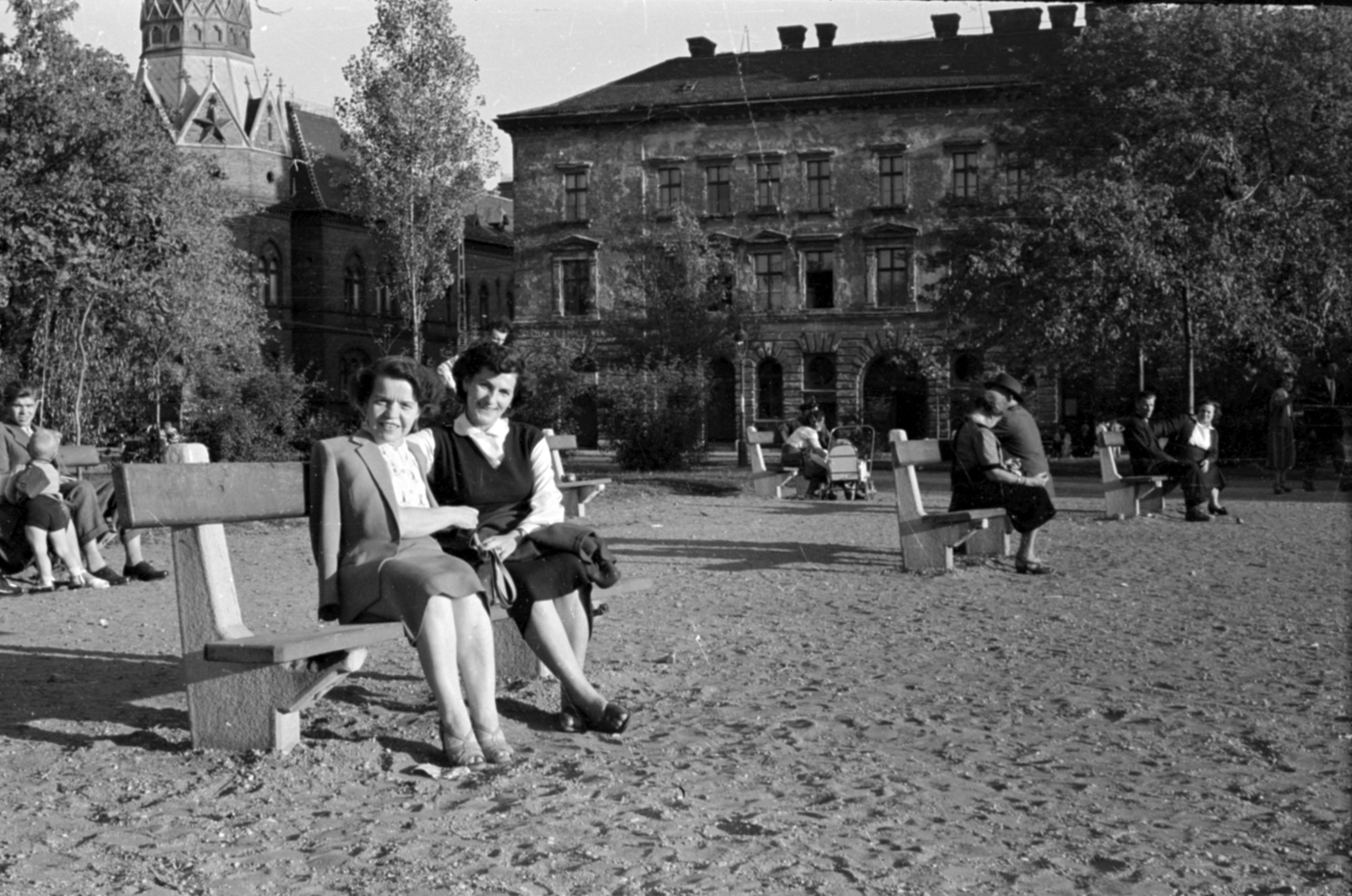 Magyarország, Budapest VIII., II. János Pál pápa (Köztársaság) tér, balra a Dologház (Szántó Kovács János) utca - Kun utca sarkán álló Tűzoltóparancsnokság épülete látszik., 1958, Fortepan/Album027, Budapest, pihenés, pad, nők, Fortepan #148900