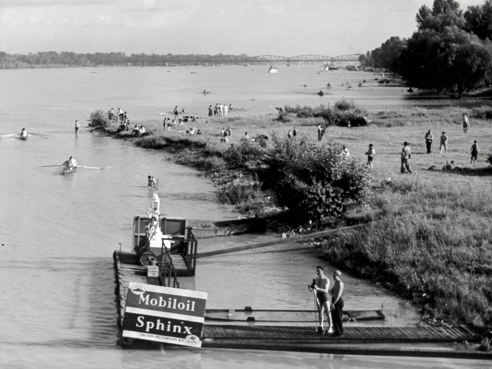 Magyarország, Budapest III., Római part a Temesvári (Horthy Miklós) utcától nézve, háttérben az Újpesti vasúti híd., 1935, Szöllősy Kálmán, evezés, fotózás, Mobiloil-márka, Budapest, Mobiloil-márka, Fortepan #149515