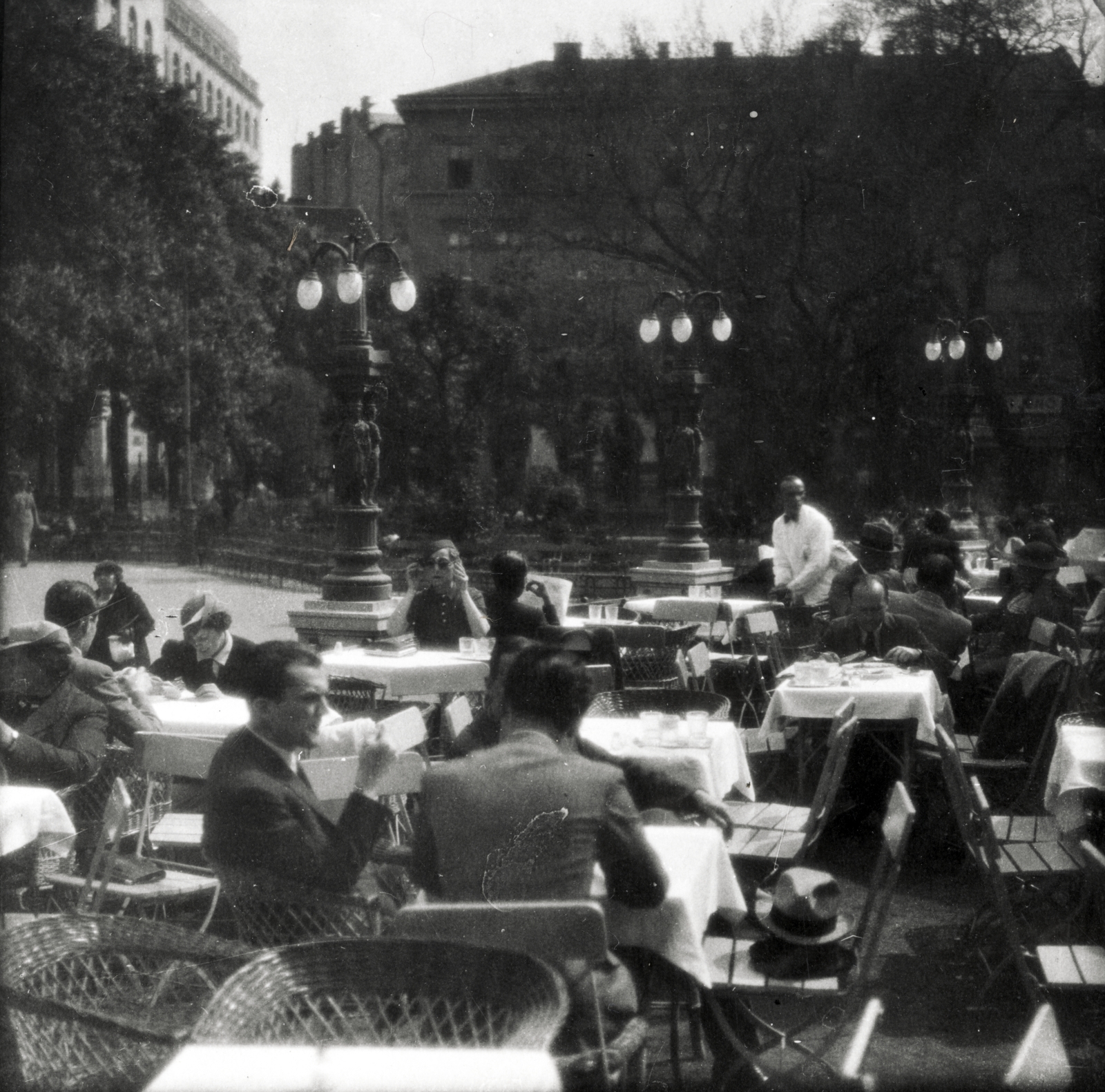 Magyarország, Budapest V., Erzsébet tér, a Nemzeti Szalon (egykor Kioszk) terasza, háttérben balra az Adria Biztosító székházának Miatyánk utcai frontja, jobbra Deák Ferenc utcai házak., 1937, Szöllősy Kálmán, fonott szék, kerthelyiség, Budapest, Fortepan #149529