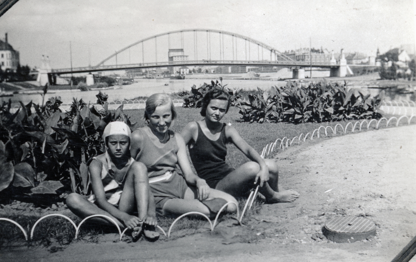 Hungary, Győr, a Mosoni-Duna és a Rába összefolyása, háttérben a Kossuth híd., 1932, Varga Csaba dr., bathing suit, bridge, girl, József Beke-design, sitting on the ground, Fortepan #150595