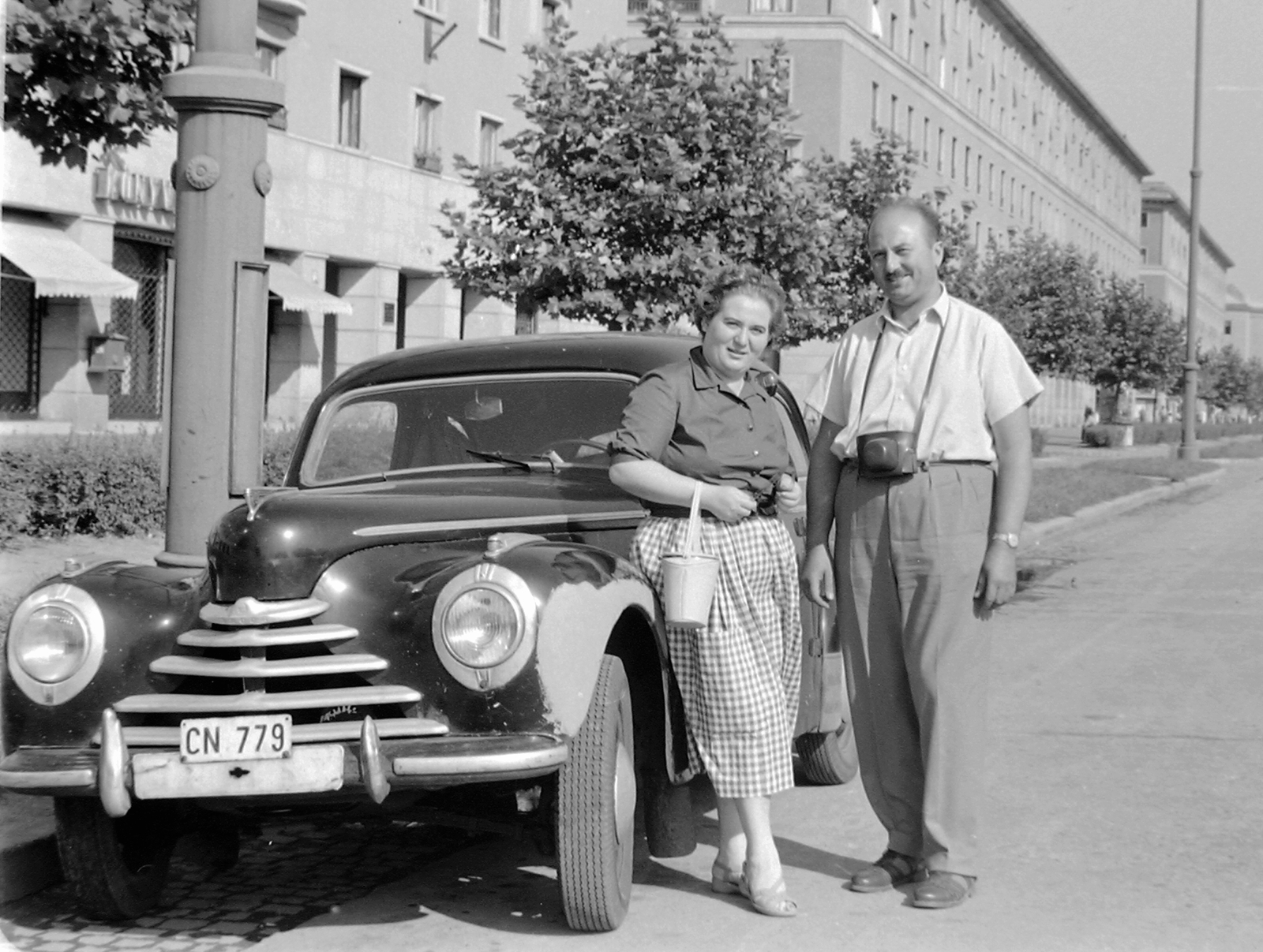 Hungary, Dunaújváros, (Sztálinváros), Vasmű (Sztálin) út. Skoda 1101 személygépkocsi., 1958, Fortepan, Czechoslovak brand, street view, Skoda-brand, couple, camera, socialist realism, automobile, number plate, Fortepan #1509