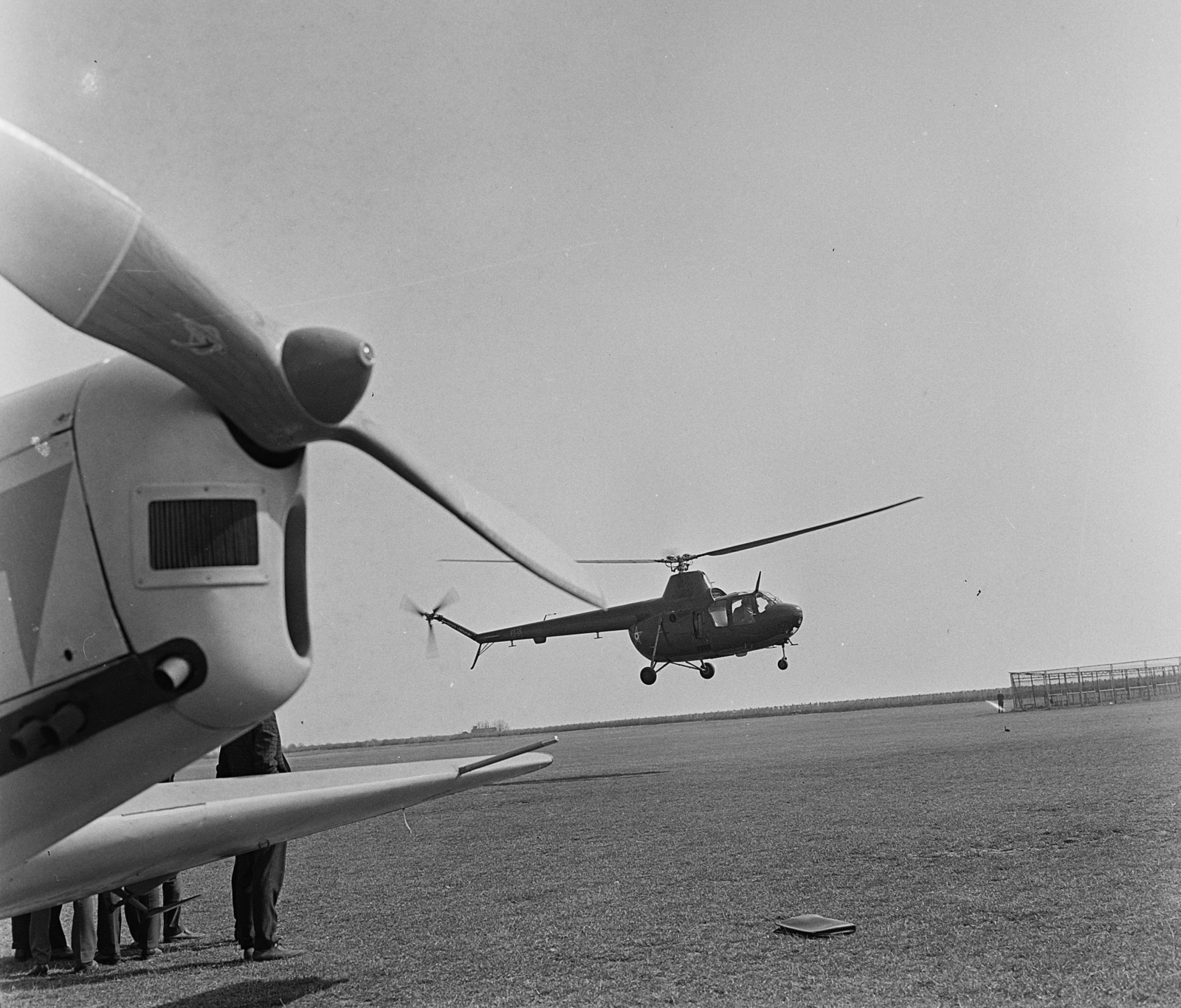 Magyarország, Budaörsi repülőtér, Budapest XI., Zlin Trener repülőgép az előtérben, a háttérben egy Mi-1 típusú katonai helikopter., 1968, MHSZ, közlekedés, csehszlovák gyártmány, szovjet gyártmány, repülőgép, katonaság, helikopter, repülőtér, Zlin-márka, légcsavar, Mil-márka, Mil Mi-1, Zlin Z-226, Budapest, Fortepan #15348