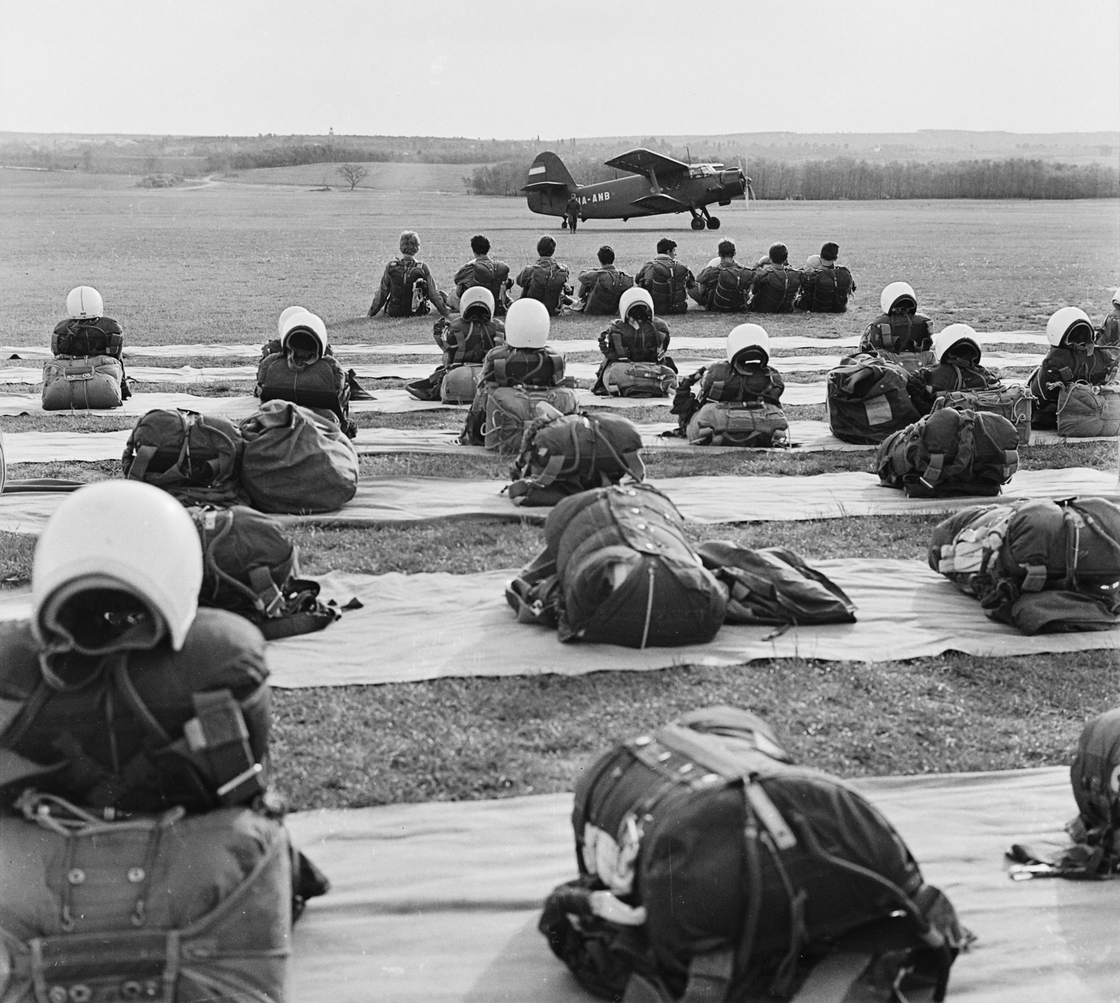 Magyarország, Gödöllő, repülőtér, ejtőernyősök, háttérben egy Antonov An-2 típusú repülőgép., 1965, MHSZ, közlekedés, szovjet gyártmány, repülőgép, katonaság, repülőtér, Antonov-márka, Antonov An-2, ejtőernyős, ejtőernyő, Fortepan #15352