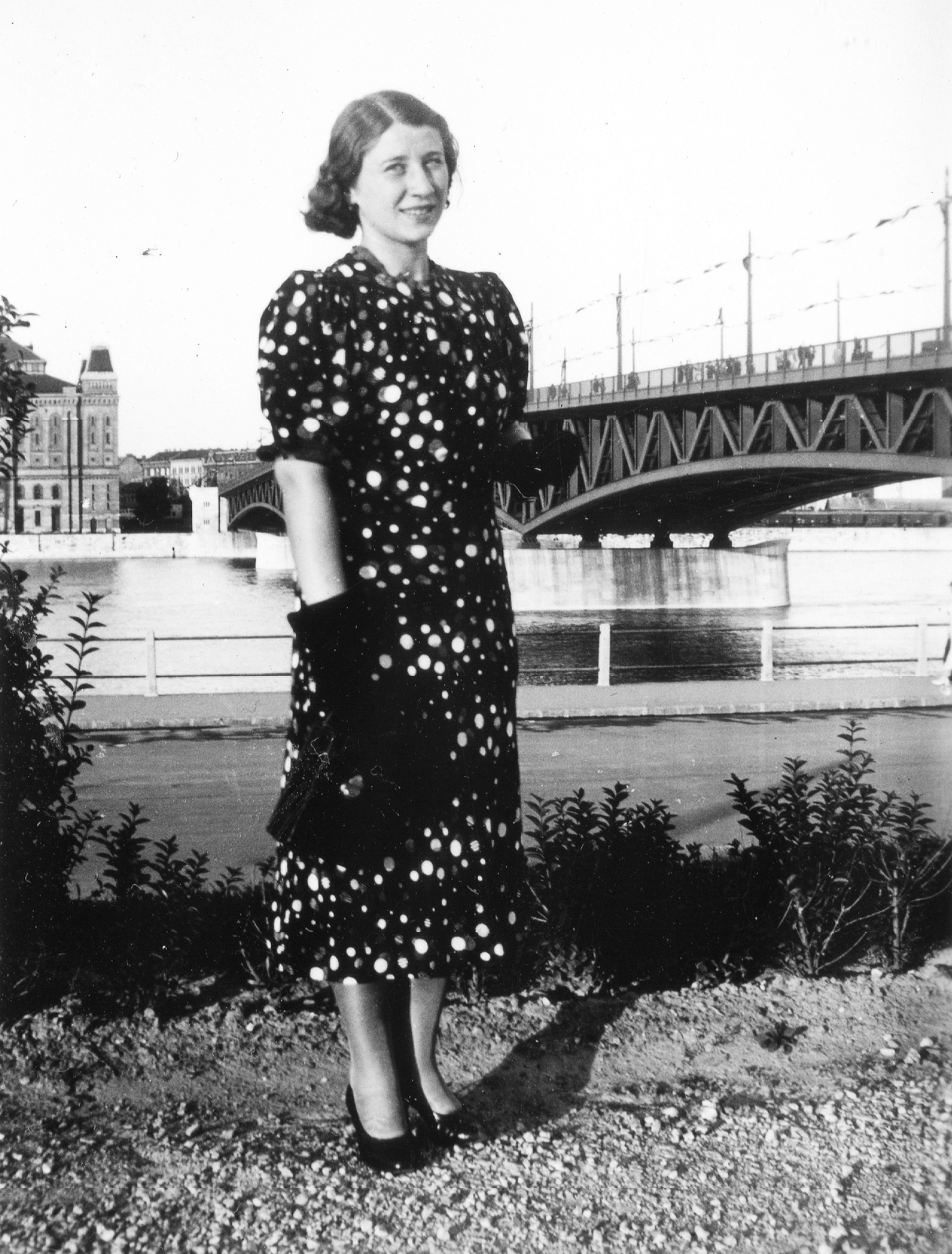 Hungary, Budapest XI., a Haditengerészeti Hősi Emlékmű előtt, a háttérben a pesti oldalon az Elevátor-ház., 1943, Orosz Heléna, portrait, bridge, gloves, handbag, lady, Danube, warehouse, Budapest, summer dresses, grain elevator, Christian Ulrich-design, Fortepan #15449