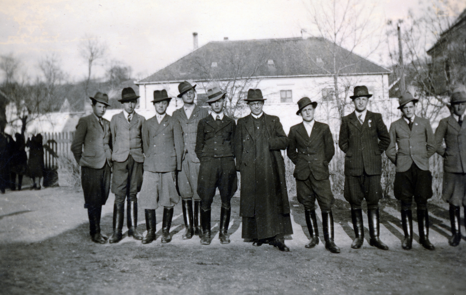 Magyarország, Kajárpéc, (Kajár) Teleki utca, háttérben a katolikus iskola épülete., 1934, Lénárt András, férfiak, pap, ünneplő ruha, csizma, Fortepan #160052