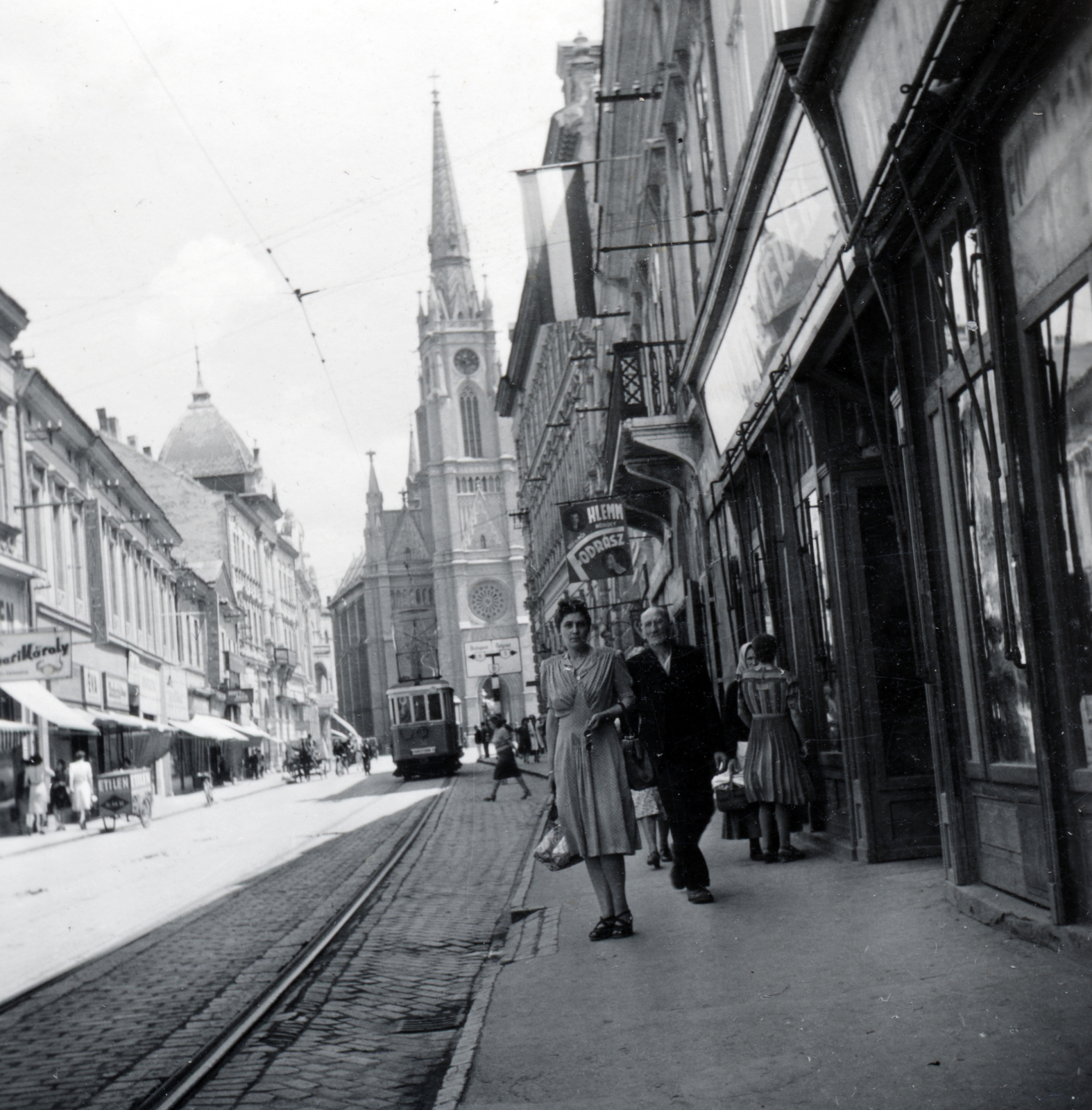 Serbia, Novi Sad, Rákóczi Ferenc utca (később Pozorišni trg) a Trg Slobode (eredetileg Ferenc József tér, késöbb Országzászló tér) felé nézve, háttérben a Szűz Mária Szent Neve-templom (Crkva imena Marijinog)., 1941, Szalai Veronika, tram, Fortepan #161268