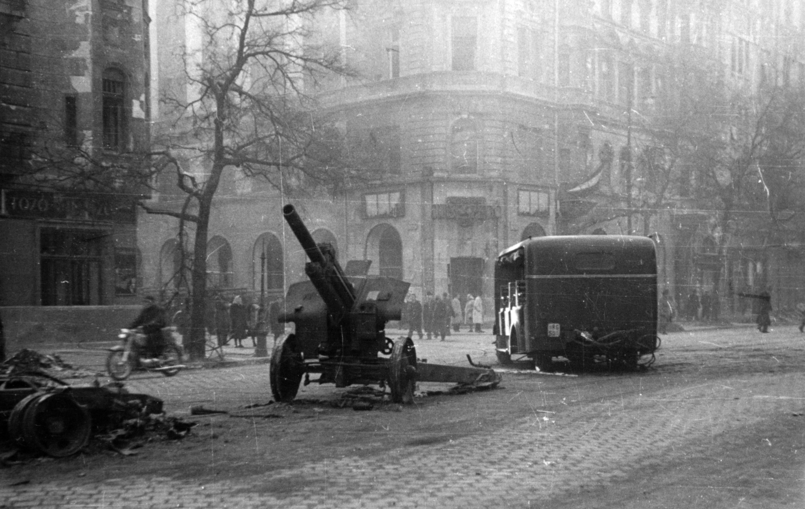 Hungary, Budapest IX., Ferenc körút a Tompa utca torkolatánál. A 38M. 122 mm-es szovjet tarack mellett egy Csepel D-350 rendőrségi riadókocsi roncsa., 1956, Gödér Hajnal, Budapest, M30 howitzer, street view, wreck, Fortepan #163275