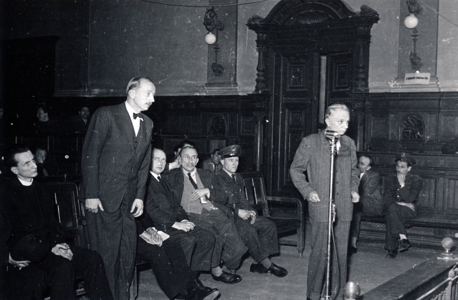 Magyarország, Budapest V., Markó utca 27., a Fővárosi Törvényszék épületének nagy esküdtszéki terme. A Budapesti Népbíróság különtanácsa által lefolytatott Mindszenty József bíboros, hercegprímás és vádlott társainak koncepciós pere 1949. február 3-5 között. A mikrofonnál dr. Horváth Gábor Eszterházy Pál jogtanácsosa, balra a vádlottak padján Zakar András érseki titkár, Esterházy Pál herceg, dr. Ispánki Béla egyetemi lelkész, Tóth László a Nemzeti Újság volt főszerkesztője., 1949, Fortepan/Album045, Bass Tibor, Budapest, bírósági tárgyalás, tanú, Fortepan #164851