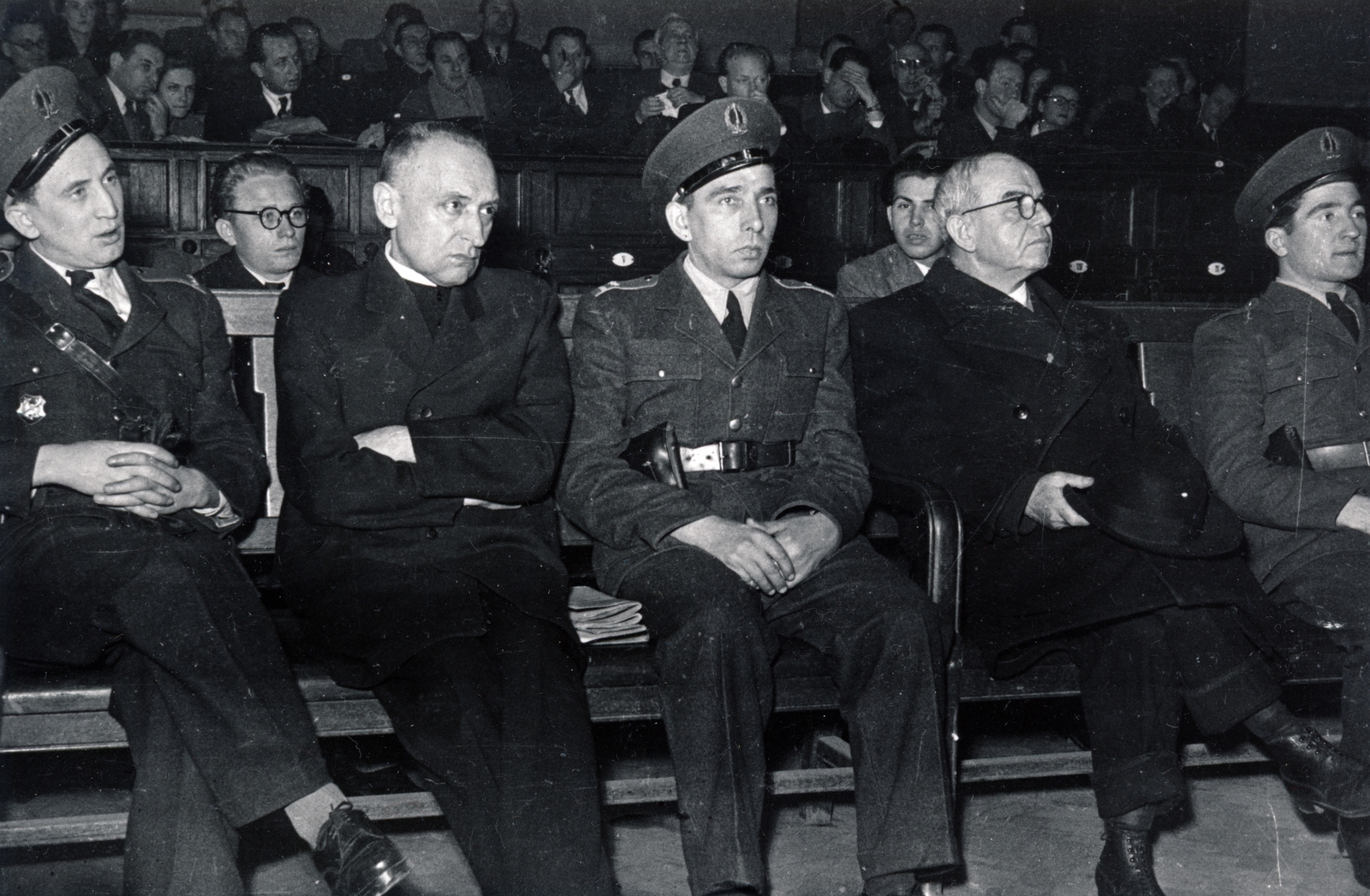 Magyarország, Budapest V., Markó utca 27., a Fővárosi Törvényszék épületének nagy esküdtszéki terme. A Budapesti Népbíróság különtanácsa által lefolytatott Mindszenty József bíboros, hercegprímás és vádlott társainak koncepciós pere 1949. február 3-5 között. Mindszenty József bíboros, hercegprímás és kalappal a kezében dr. Baranyay Jusztin ciszterci szerzetes, egyházjogász, egyetemi tanár., 1949, Fortepan/Album045, Bass Tibor, Budapest, bírósági tárgyalás, Fortepan #164872