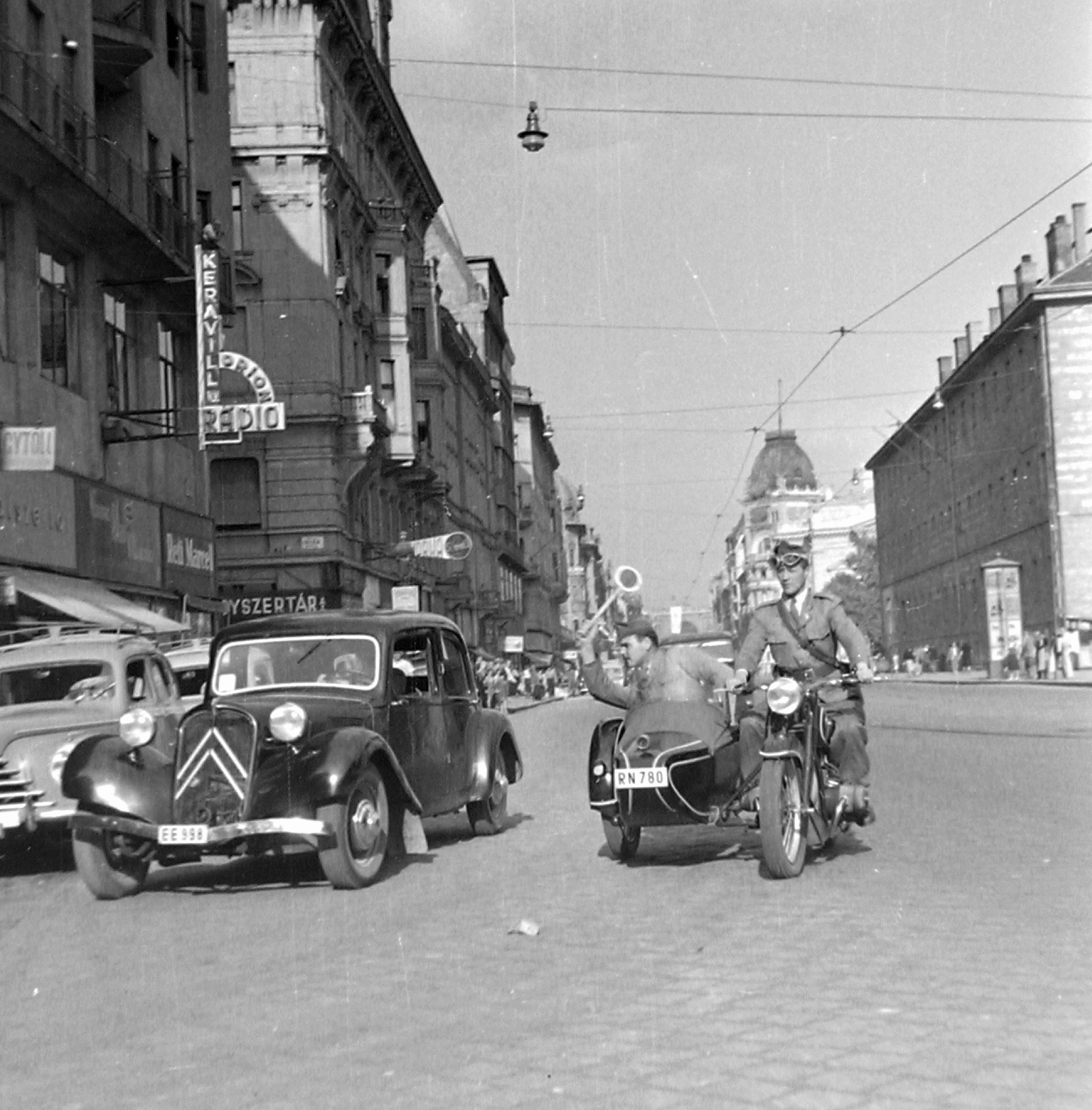 Hungary, Budapest VIII.,Budapest VII., Rákóczi út, jobbra a Rókus kórház. BMW R-51 oldalkocsis motorkerékpár, a rendőr Citroën 11-es típusú személygépkocsit állít meg., 1950, Magyar Rendőr, sign-board, street view, genre painting, Skoda-brand, neon sign, BMW-brand, cop, motorcycle with sidecar, Citroën-brand, Budapest, Fortepan #16616