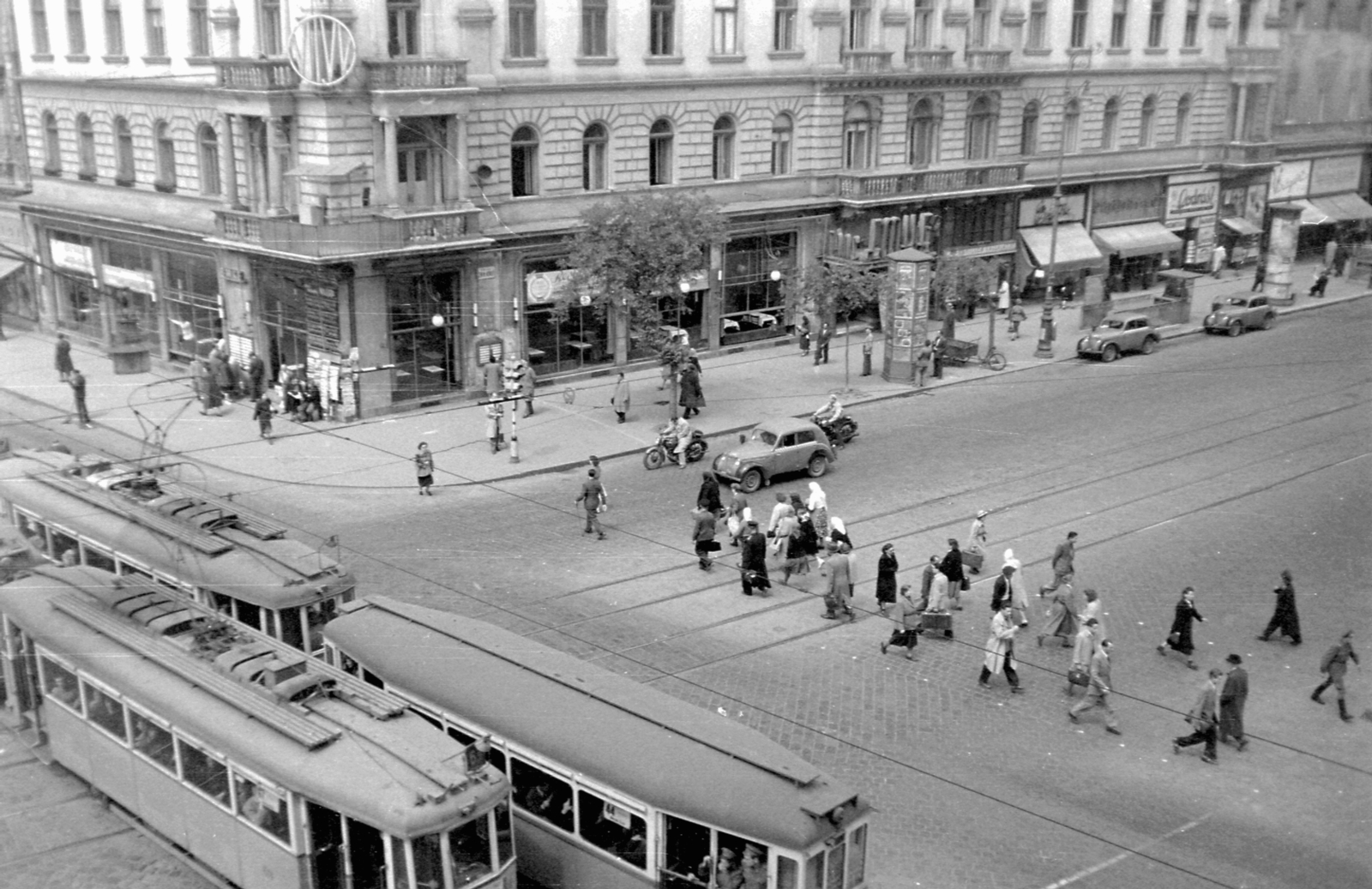 Magyarország, Budapest VII., Rákóczi út - Erzsébet (Lenin) körút sarok. Érdekes a két I. emeleti erkélyt összekötő szerkezet, tetővel, a forgalomirányító rendőr számára., 1952, Magyar Rendőr, közlekedés, motorkerékpár, utcakép, taxi, Renault-márka, francia gyártmány, villamos, hirdetőoszlop, Renault Juvaquatre, Budapest, Fortepan #16798