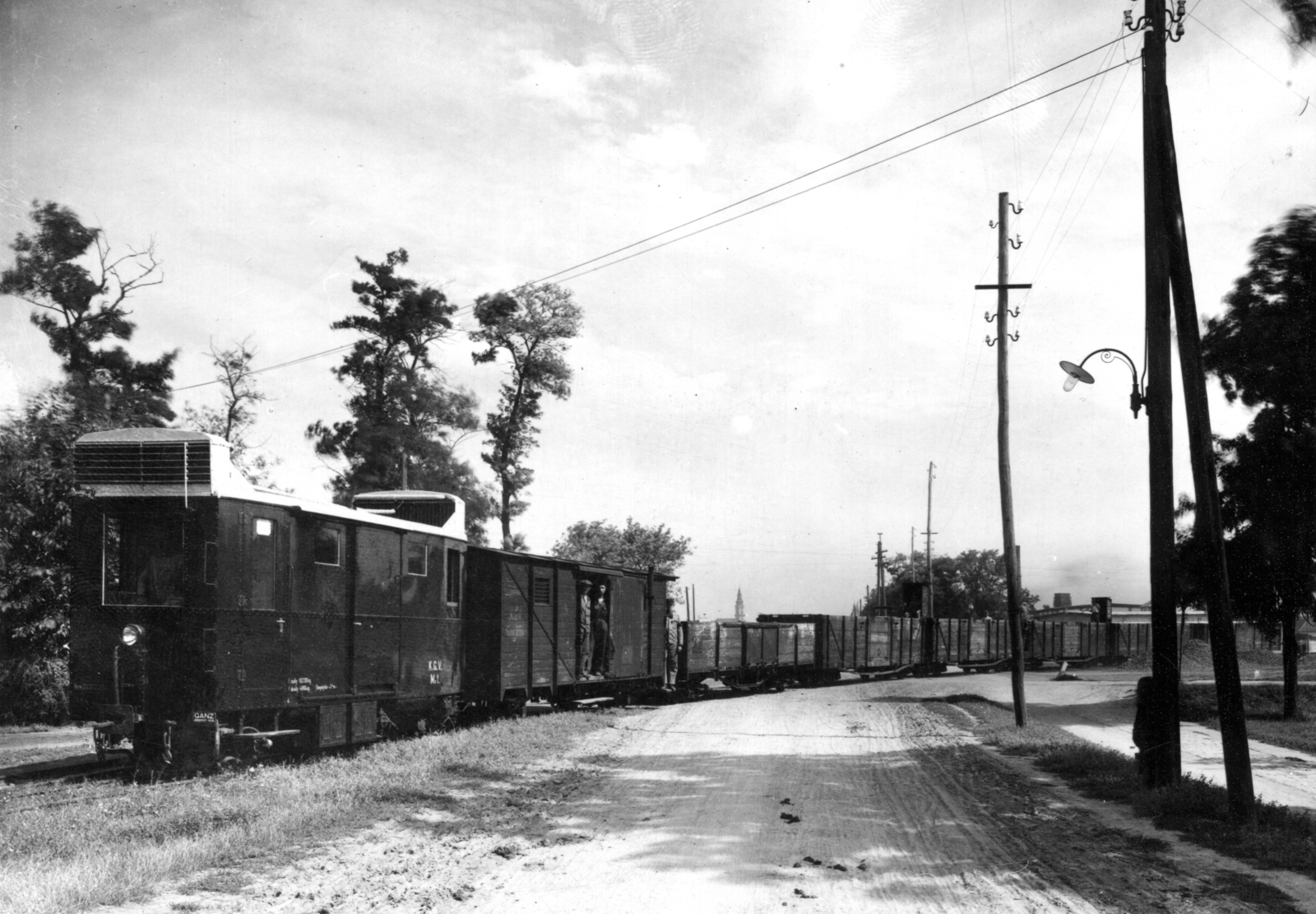 Hungary, Kecskemét, a Halasi út Kecskemét alsó vasútállomásnál. A Kecskeméti Gazdasági Vasút keskeny nyomtávú vonala. Elöl az 1935-ben gyártott, GANZ diesel-mechanikus, poggyászteres motorkocsi. Távolban a Nagytemplom tornya látszik., 1936, Villányi György, rail, narrow-gauge railway, , Fortepan #170277