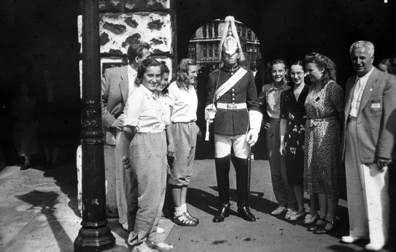 United Kingdom, London, átjáró a Királyi Lovas Testőrség laktanyájának nyitott udvara, a Horse Guards Parade felől a Whitehall felé. Littomeritzky Mária, Székely Éva, Zságot Irén és Temes Judit olimpikon úszónők, jobb szélen Hegyi Gyula sportvezető. A felvétel a XIV. nyári olimpiai játékok idején készült., 1948, Sárosi Imre, women, sportsperson, Fortepan #170936