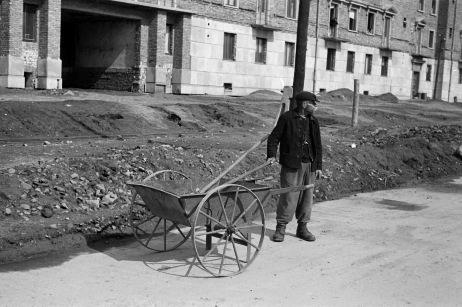 Hungary, Dunaújváros, (Sztálinváros), Vasmű (Sztálin) út, háttérben az Erkel Ferenc kert épülete., 1953, Sattler Katalin, wheelbarrow, Fortepan #171114