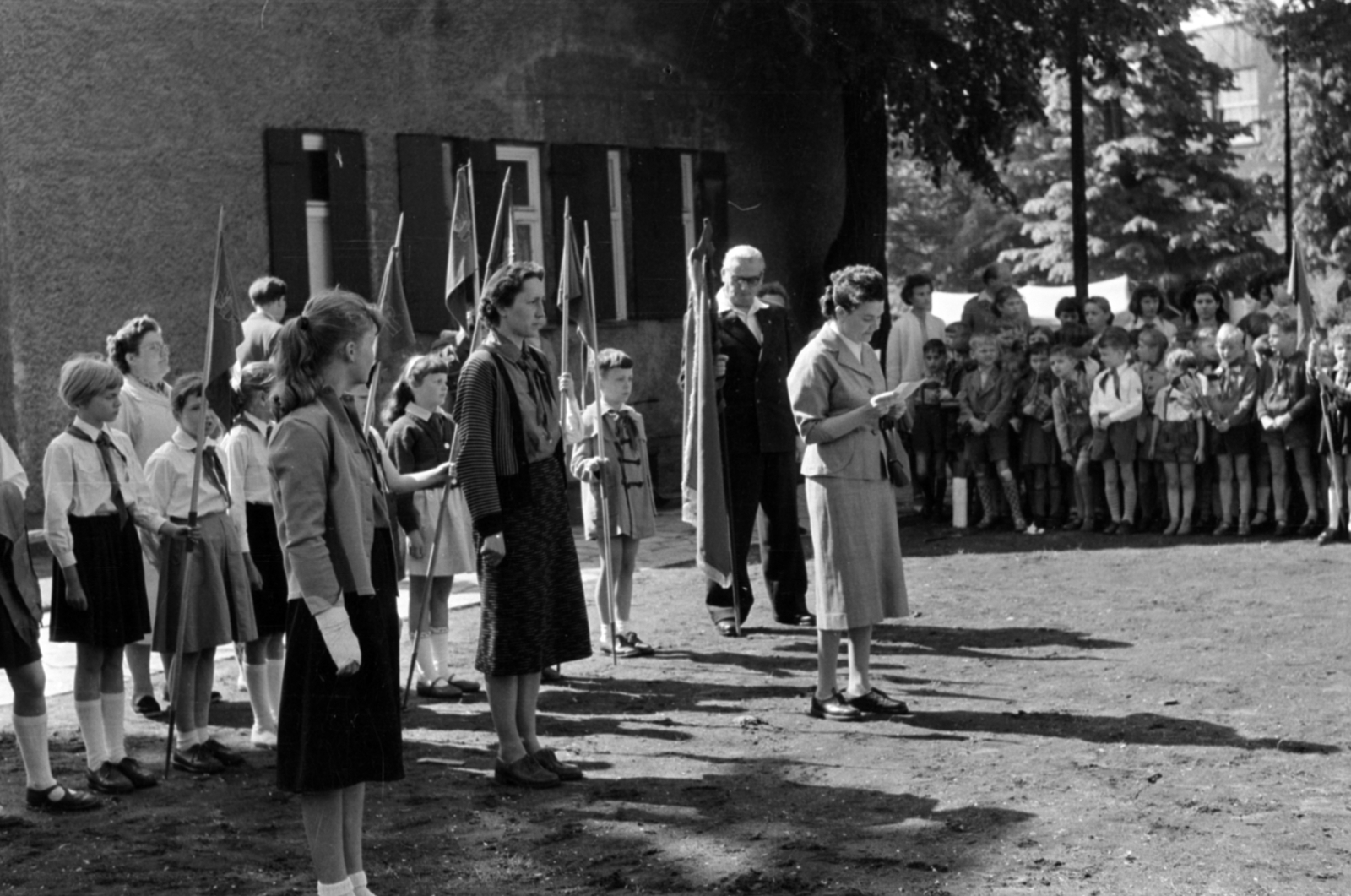 Németország, Berlin, Kelet-Berlin, Neue Krugallee 31., a 3. Grundschule Bezirk Treptow (Treptow kerületi 3. sz. általános iskola) úttörői a Plänterwald parkban, a fák között a Neue Krugallee 28. látszik., 1958, Sattler Katalin, NDK, Kelet-Berlin, Fortepan #171261