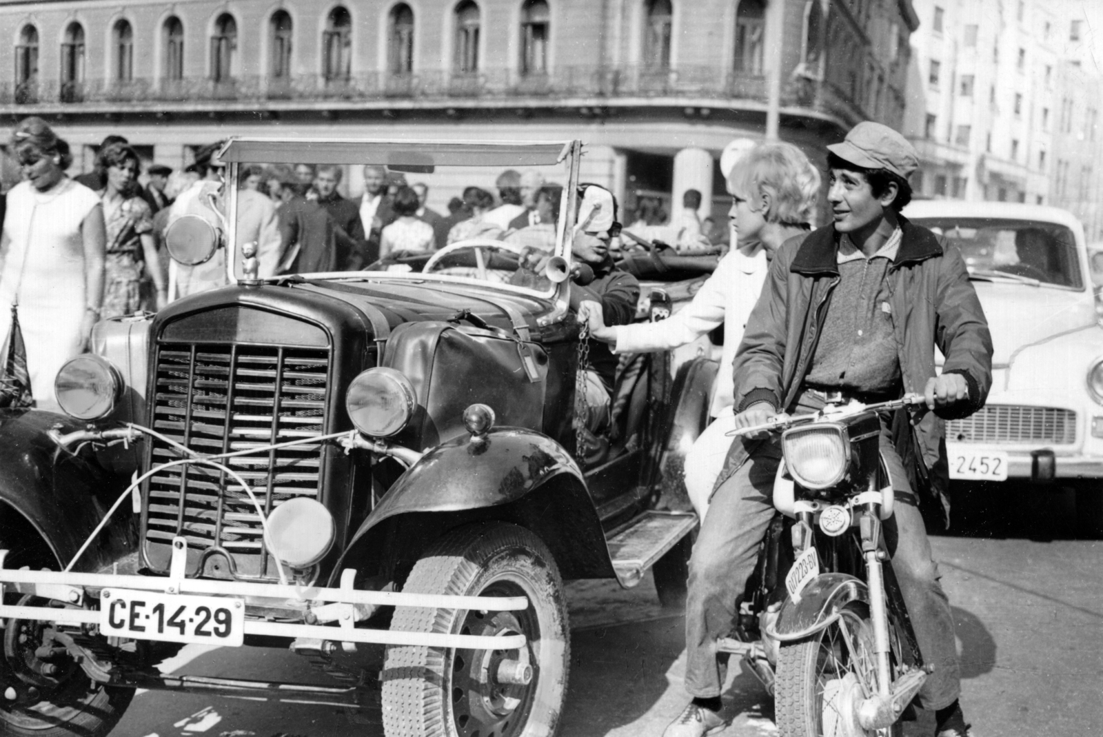 Romania, Bucharest, Calea Victoriei, balra a strada Constantin Mille, háttérben a Hotel Capitol. A kép Makk Károly Bolondos vakáció című (1968) filmjének forgatásán készült. A kormány mögött Sztankay István, a motoron Borbáth Ottília színművészek., 1967, Sütő András örökösei, Új Élet szerkesztőség, motorcycle, automobile, number plate, prop, Fortepan #174689