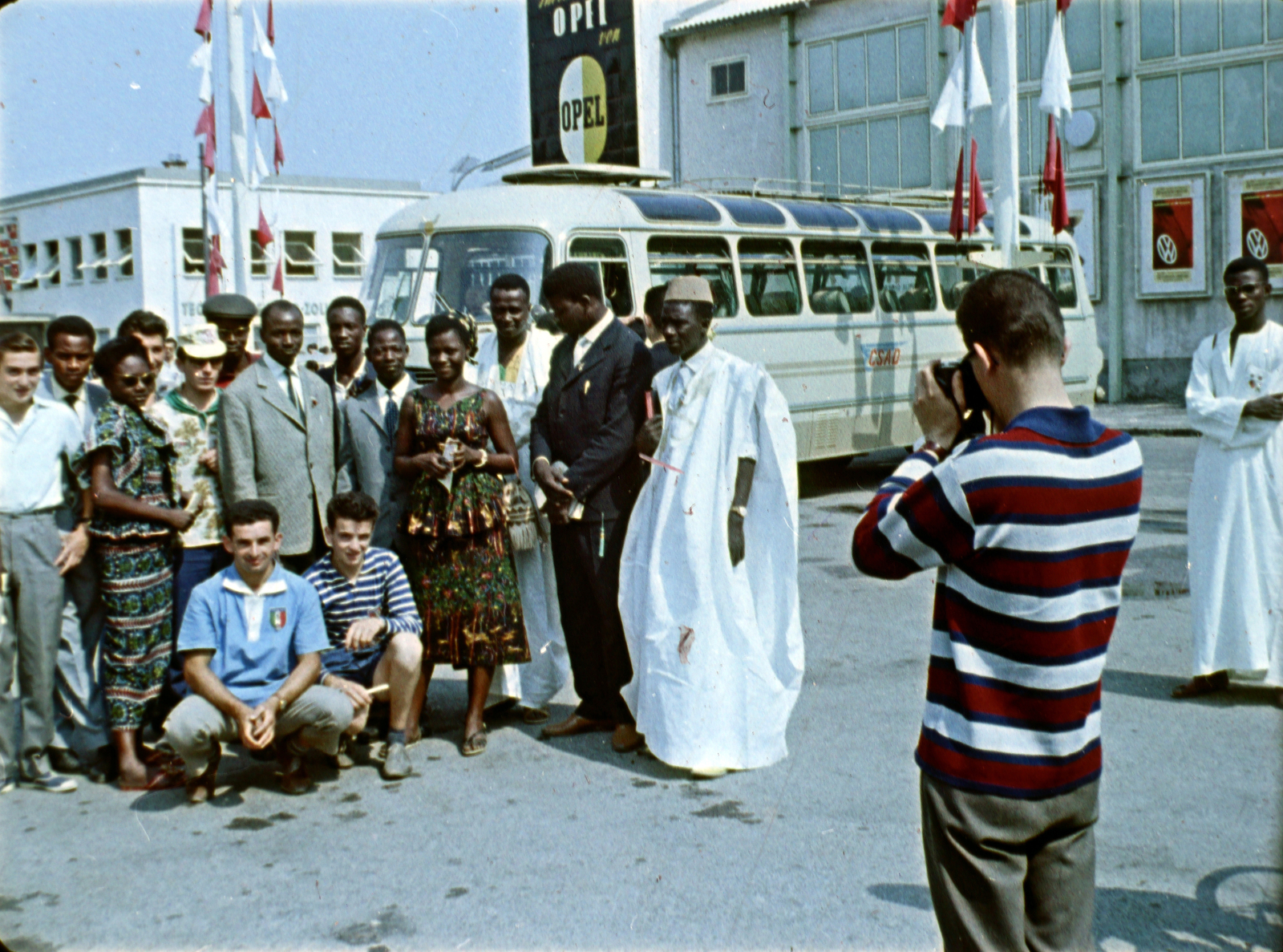 Ausztria, Bécs, a Messe Wien (kiállítási és kongresszusi központ) déli bejárata előtt a VII. VIT (Világifjúsági Találkozó) résztvevői. Filmkocka a Bécsben találkoztunk című kisfilmből, rendező Kolonics Ilona, operatőrök Szabó Árpád és Fifilina József., 1959, Szabó Gábor, színes, Fortepan #174803