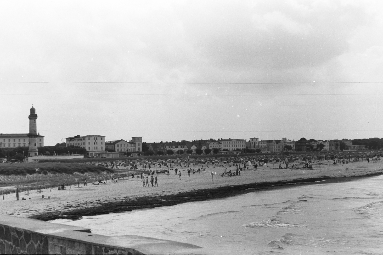 Németország, Warnemünde, Rostock, sétány a Nyugati móló (Westmole) felé az Alter Strom kikötőnél. Szemben a strand és a régi világítótorony., 1961, Chuckyeager tumblr, NDK, Fortepan #175938