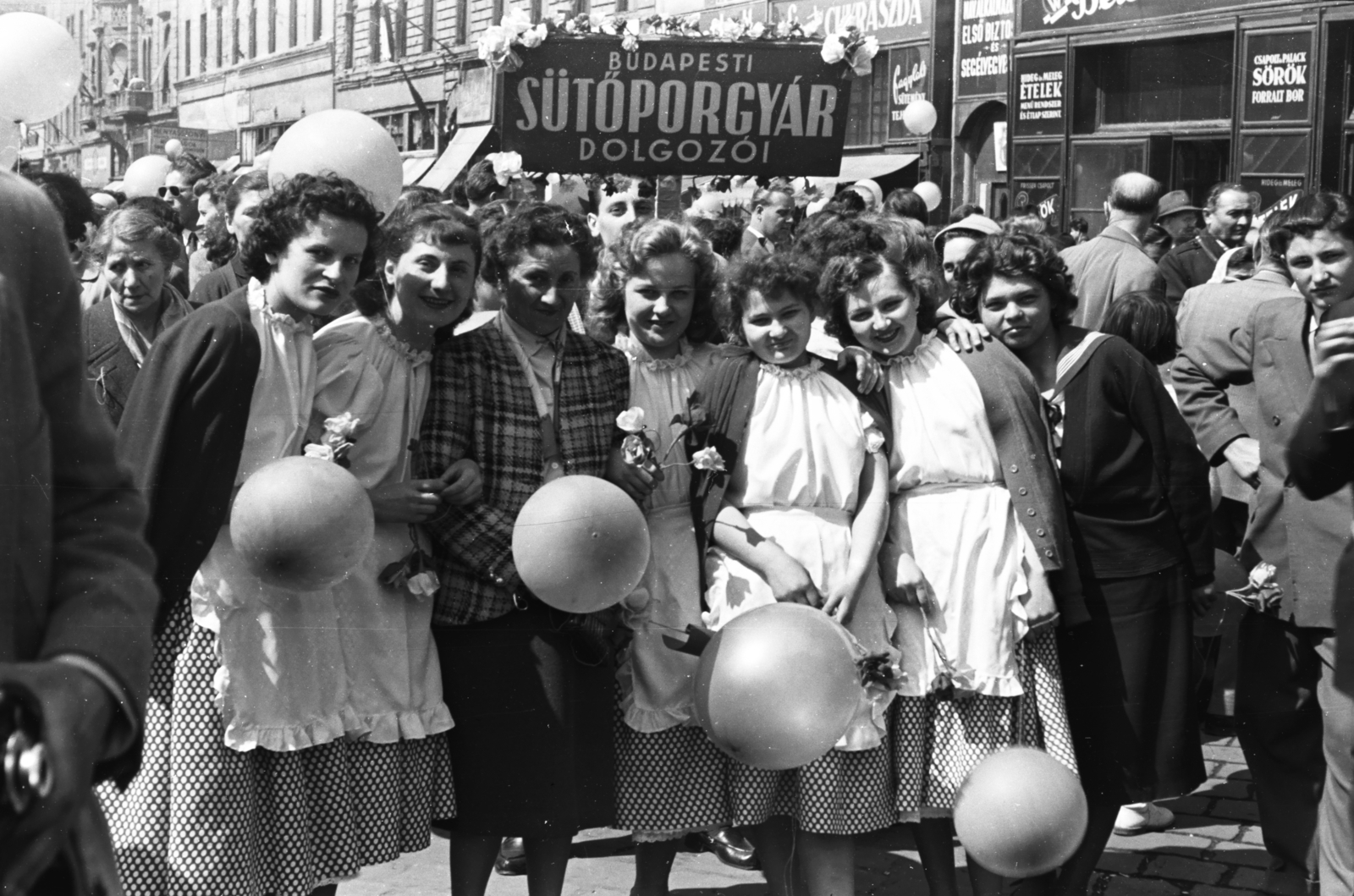 Magyarország, Budapest VII., Baross tér, május 1-i felvonulás résztvevői a Rottenbiller utca - Bethlen Gábor utca közötti házsor előtt., 1958, Chuckyeager tumblr, Budapest, léggömb, nők, mosoly, kötény, Fortepan #176056