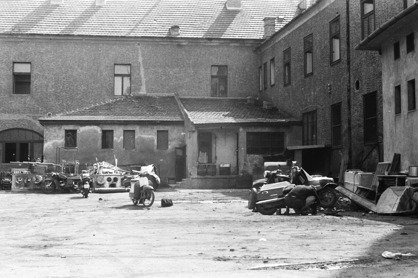Magyarország, Veszprém, Óvári Ferenc (Sztálin) út - Megyeház (Puskin) tér sarok. A Bakony Szálló és Étterem gazdasági udvara a Petőfi Színház felől nézve., 1962, Chuckyeager tumblr, motorkerékpár, hordó, tűzhely, dézsa, motorszerelés, szerelés, Csepel Panni, szemét, Fortepan #176076