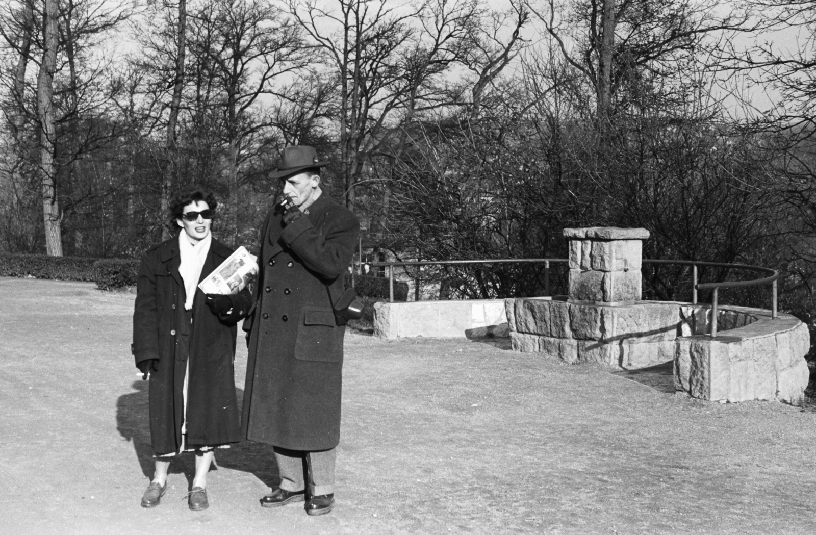 Hungary, Budapest II., a felvétel a Gyermekvasút (Úttörővasút) végállomásánál készült, háttérben a mozgólépcső épületének részlete., 1957, Chuckyeager tumblr, Budapest, smoking, shades, coat, drinking fountain, Fortepan #176380