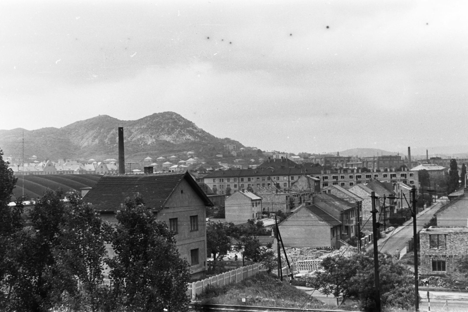 Hungary, Budapest XI., balra a Kelenföldi buszgarázs tetőzete felett a Petőfi laktanya épülete és a Sas-hegy látszik. Jobbra a Takács Menyhért (Antal János) utca házai a Hamzsabégi út és a Nagyszőlős utca között. Távolabb a Kozmetikai és Háztartásvegyipari Vállalat és a Pamuttextilművek (később Dorottya udvar) épületének részlete., 1966, Chuckyeager tumblr, railway, Budapest, Fortepan #176485
