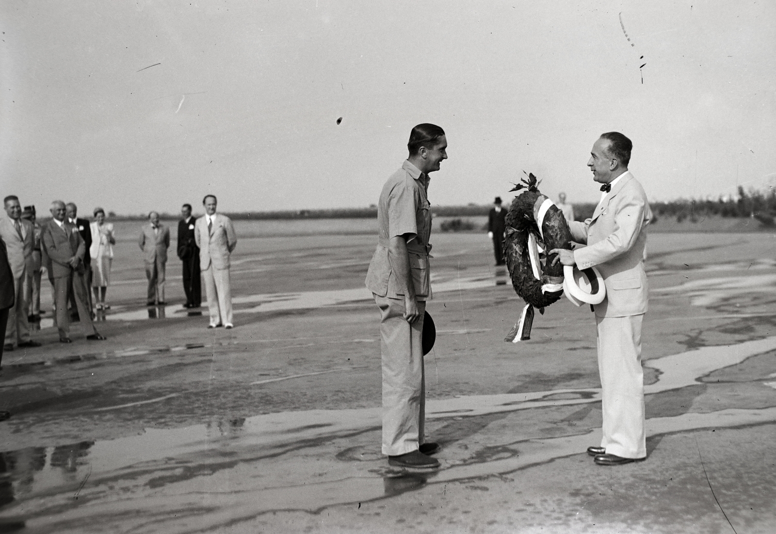 Hungary, Budaörs Airport, Budapest XI., 1939. augusztus 3-án Horthy István hazaérkezett indiai repülőútjáról, mely alkalomból Ember Sándor, a Magyar Aero Szövetség társelnöke babérkoszorút nyújt át., 1939, Bojár Sándor, Budapest, hat in hand, wreath, Fortepan #177345