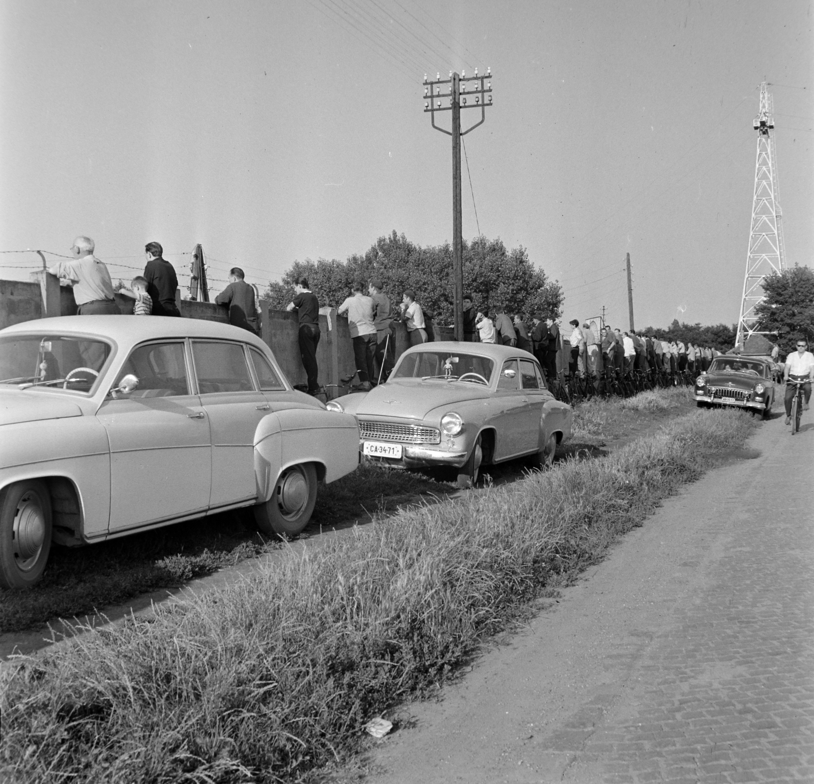 Magyarország, Szeged, Felső-Tiszapart, szurkolók a SZEOL pálya kerítésénél., 1966, Bojár Sándor, kerékpár, villanyoszlop, kerítés, szögesdrót, képarány: négyzetes, leselkedő, leleményes, rendszám, Wartburg 311/312, Fortepan #177545