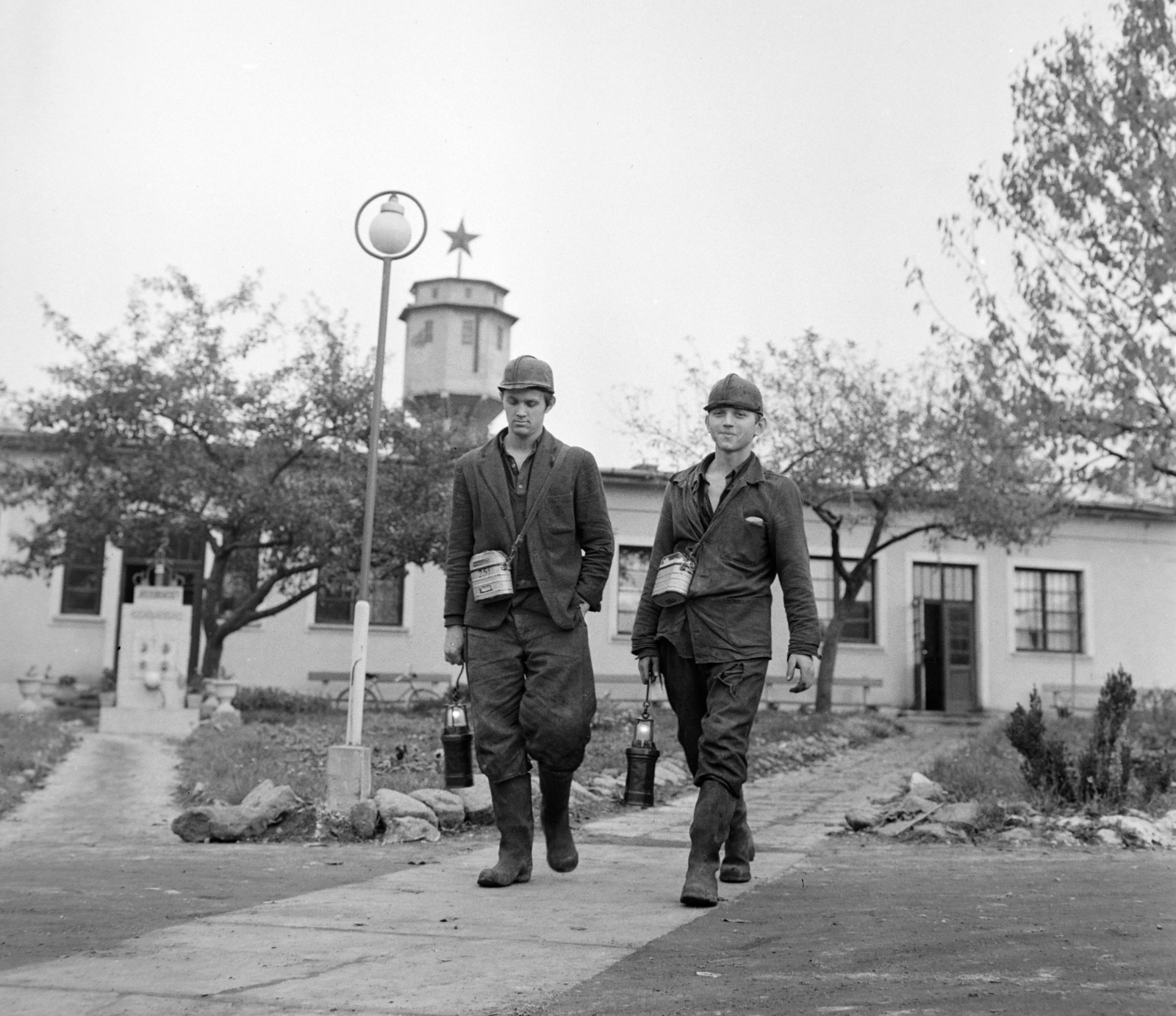 Magyarország, Tatabánya, Tatabányai Bányák Vállalat XV-ös akna, ma skanzen. Bányászok a bányaüzem parkjában, balra a hősi halottaknak állított emlékmű, háttérben a víztorony., 1964, Bojár Sándor, védősisak, bányász, Fortepan #178274