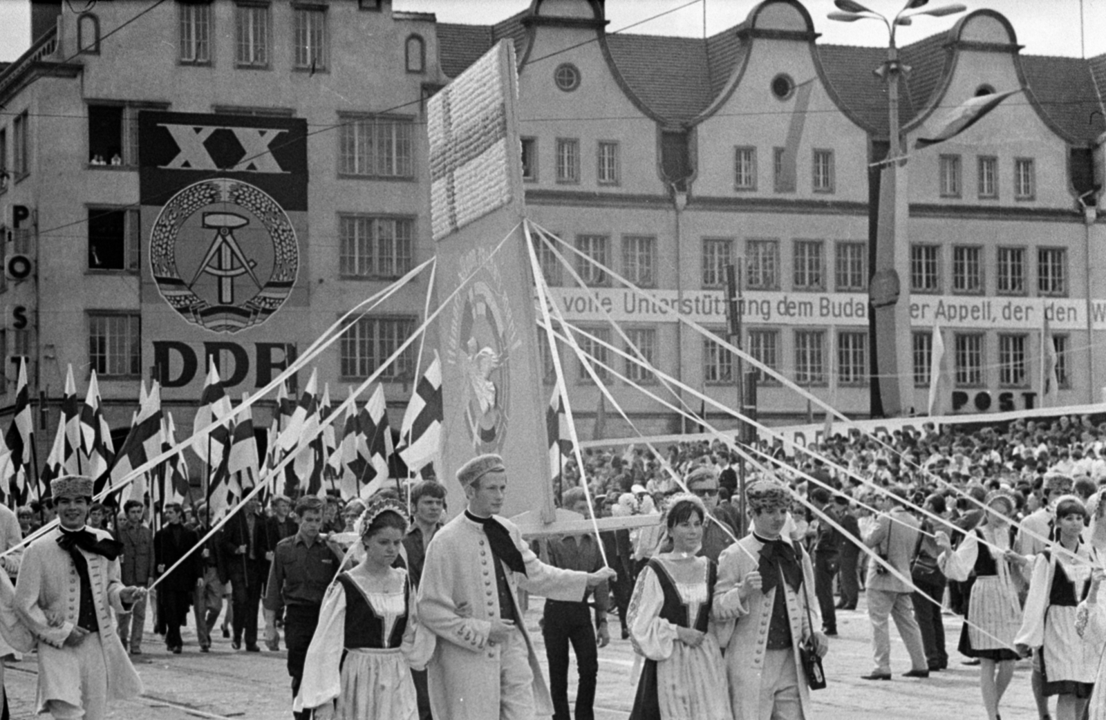 Németország, Rostock, a felvétel a Neuer Markt 3. számú épület előtt készült., 1969, Bojár Sándor, NDK, pódiumautó, népviselet, címer, Fortepan #179367