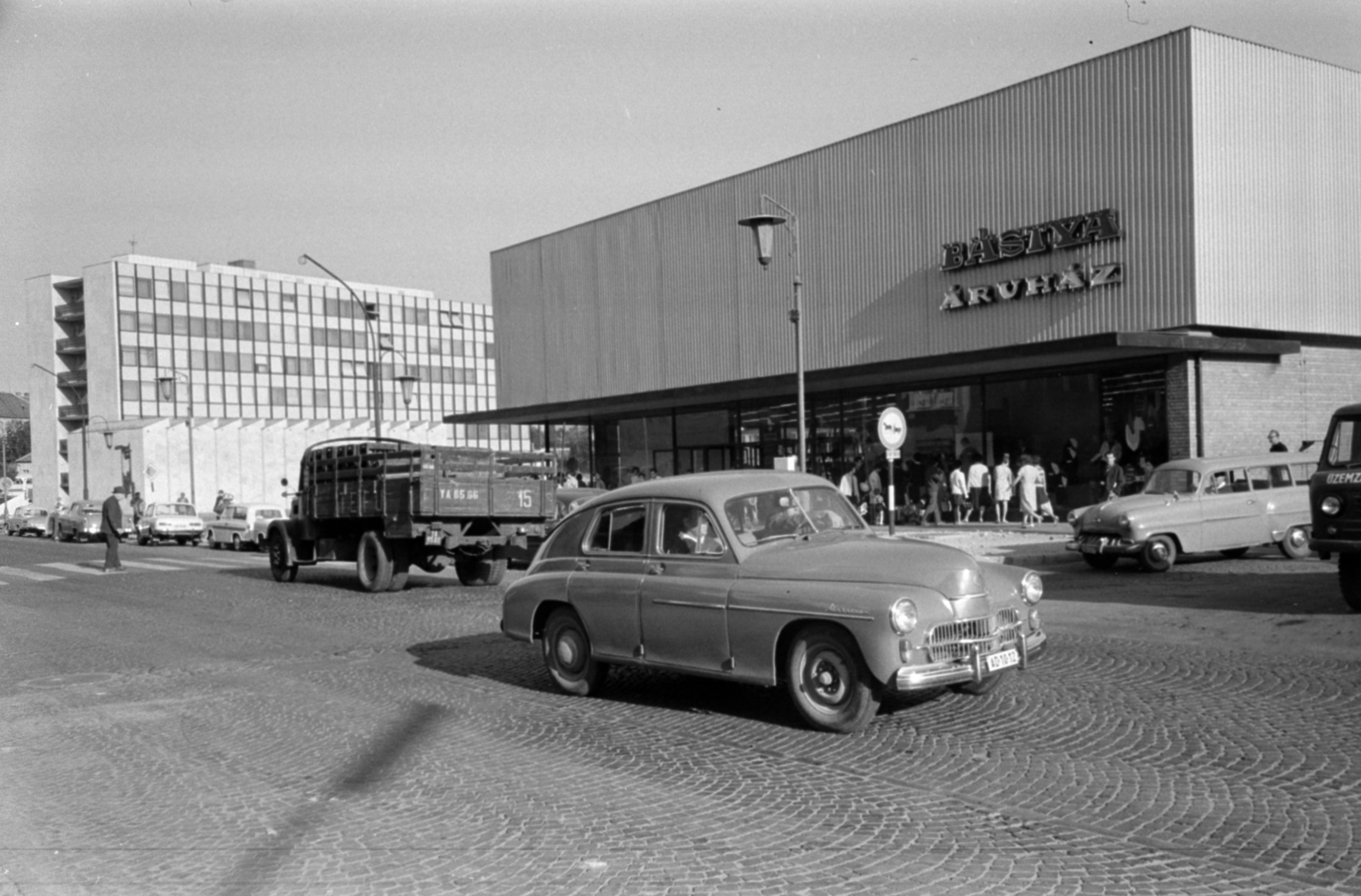 Hungary, Veszprém, Kossuth Lajos utca, Bástya Áruház, háttérben a Pártház., 1967, Bojár Sándor, commercial vehicle, street view, UAZ-brand, lamp post, store, cobblestones, automobile, board, crosswalk, Fortepan #179969