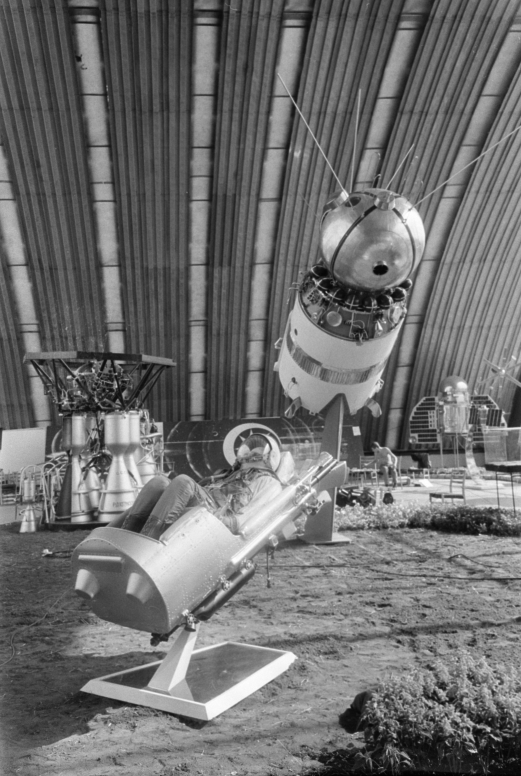 Magyarország, Városliget, Budapest XIV., a BNV területe, a Szovjet tudomány és technika 50 éve jubileumi kiállítása 1967. szeptember 1-24. A Vosztok űrhajó (a rakéta harmadik fokozatával), előtérben az űrkabin katapultülésének makettje, benne az SzK-1 szkafander. Balra a háttérben a hordozórakéta első fokozata., 1967, Bojár Sándor, Budapest, űrhajós, űrhajó, makett, Fortepan #180229