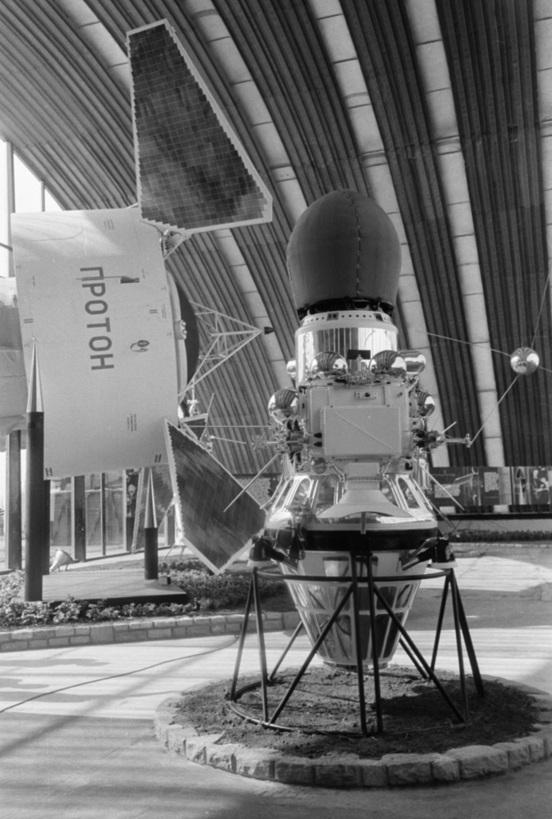 Hungary, Budapest XIV., a BNV területe, a Szovjet tudomány és technika 50 éve jubileumi kiállítása 1967. szeptember 1-24. A Luna–9 modellje, az űrszonda tetején a leszálló modullal. Háttérben a Proton-1 tudományos műhold, űrlaboratórium., 1967, Bojár Sándor, Budapest, spaceship, model, Fortepan #180234