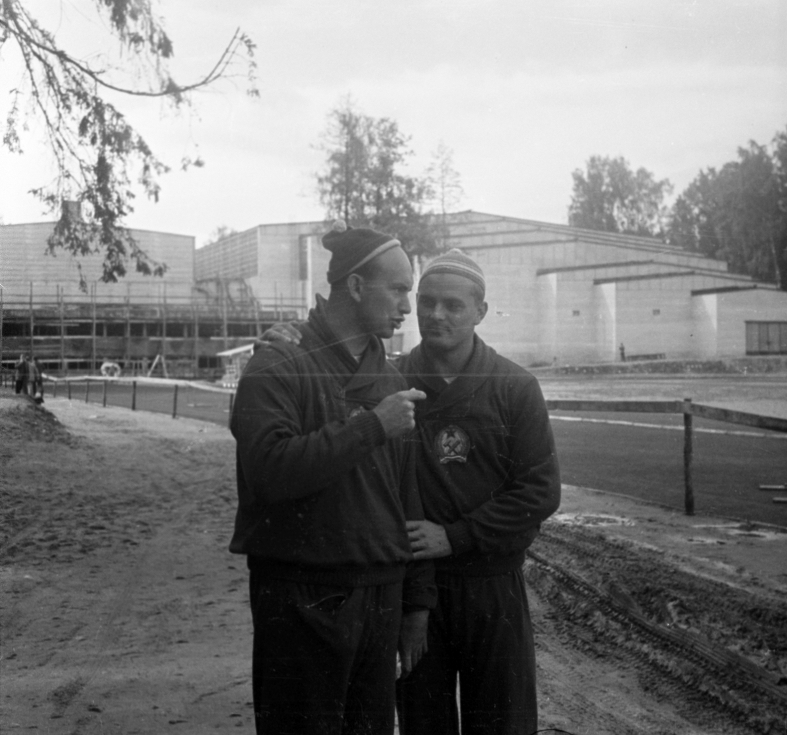 Finnország, Espoo, Németh Imre a kalapácsvetés 2. helyezettje és Csermák József a kalapácsvetés olimpiai bajnoka az otaniemi táborban. A felvétel a Helsinki-ben megrendezett XV. nyári olimpiai játékok idején készült., 1952, Bojár Sándor, sapka, férfi, olimpiai bajnok, sportoló, képarány: négyzetes, kalapácsvetés, tábor, beszélgetés, Fortepan #180462