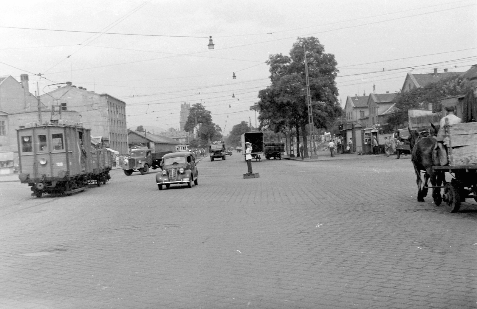 Hungary, Budapest VIII., Orczy tér a Fiumei út felé nézve, jobbra a Józsefvárosi pályaudvar., 1954, Magyar Rendőr, traffic, Horse-drawn carriage, commercial vehicle, street view, genre painting, cop, tram, coach, phone booth, gas station, cobblestones, automobile, pulpit for police officers, Budapest, Fiat-brand, Fortepan #18094